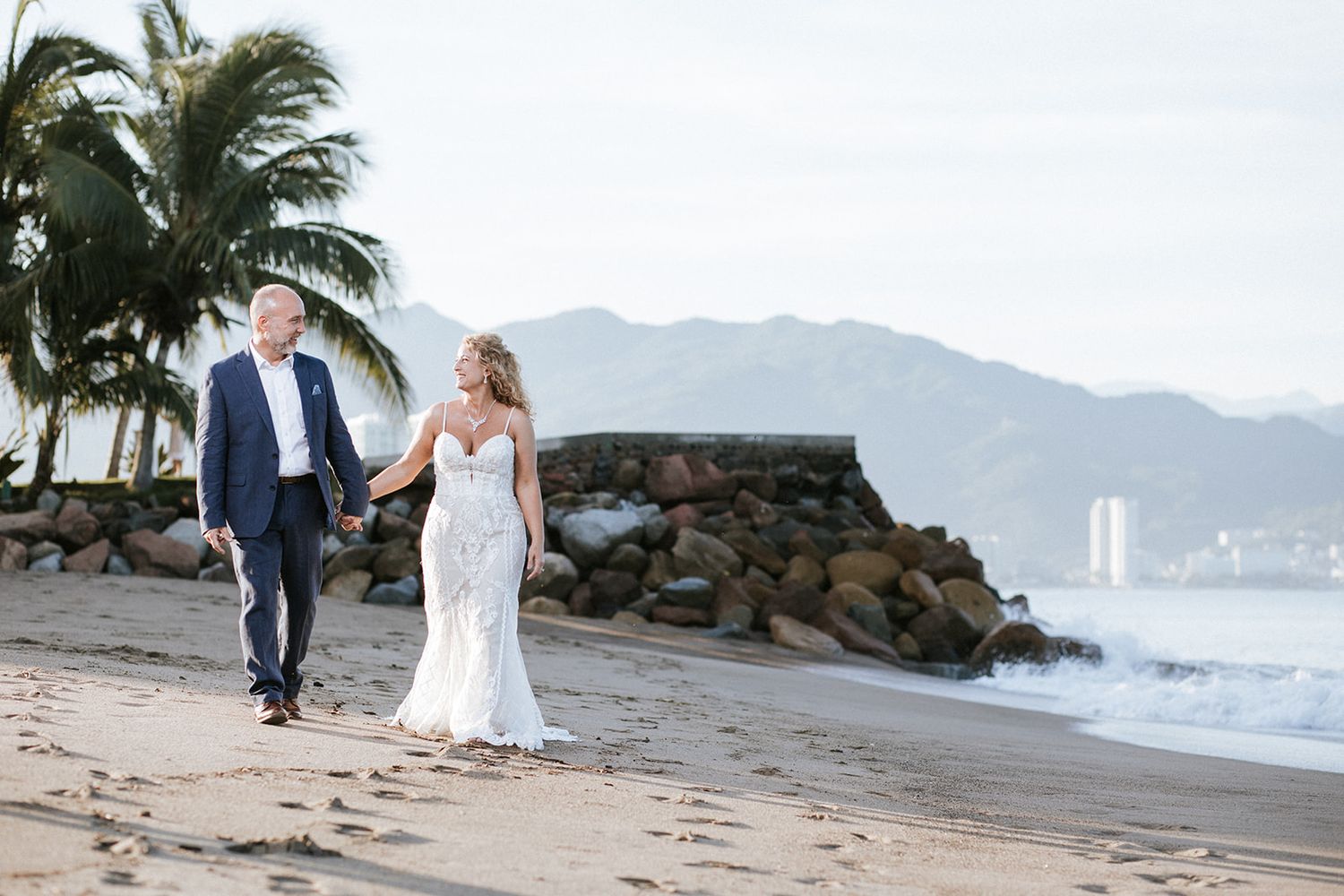 Couple walking hand in hand on the beach during their elegant Puerto Vallarta wedding, captured by destination photographer José Carrillo.
