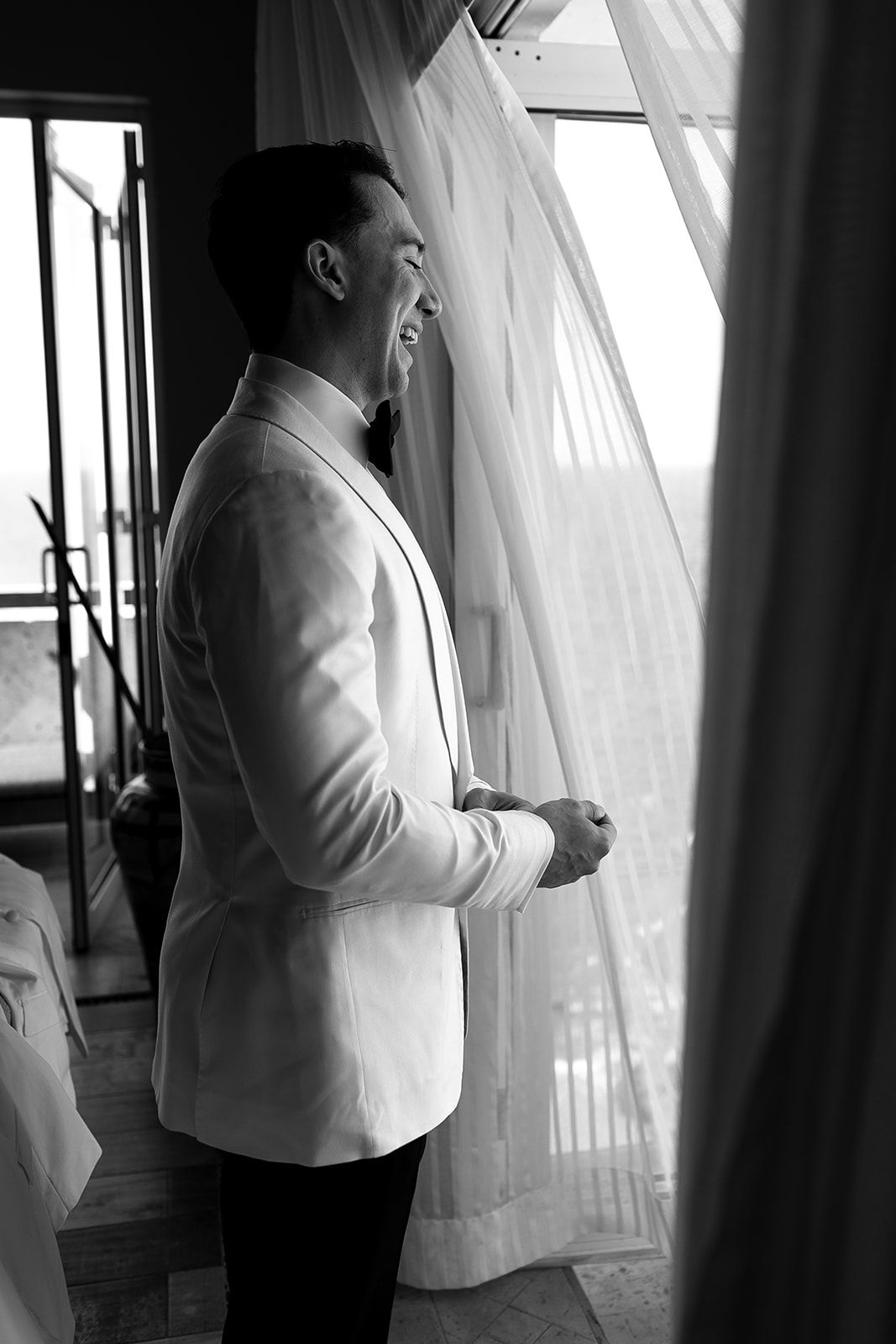 Black and white portrait of groom in white tuxedo before luxury destination wedding in Puerto Vallarta, by José Carrillo.