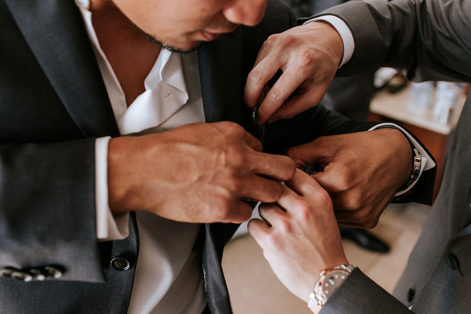 Groom getting ready with his groomsmen in Puerto Vallarta, adjusting suit details before the ceremony — captured by José Carrillo Photograph