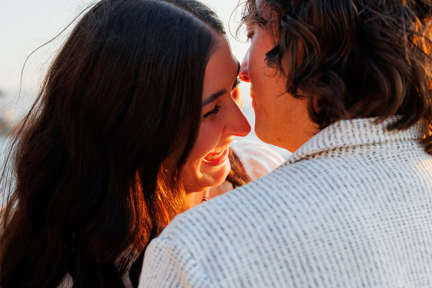 Couple shares a tender moment during a golden-hour engagement session by the sea in Puerto Vallarta, by José Carrillo Photography.