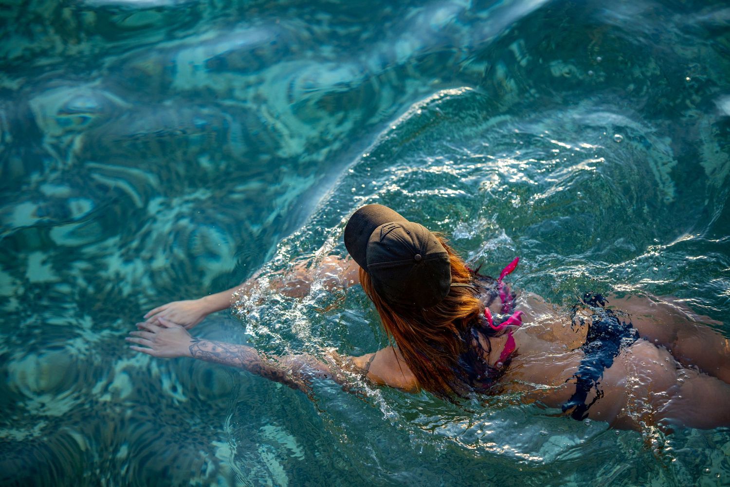 Woman swimming through an ocean rock pool in Sydney's Eastern Suburbs with clear water and flowing movement.