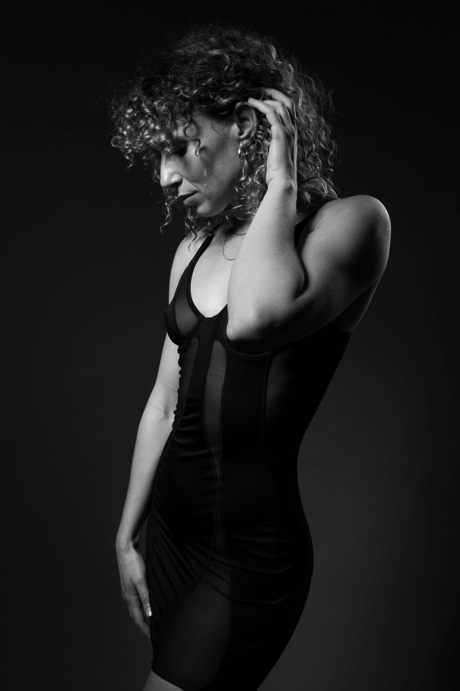 Black and white studio portrait of Freeride World Tour snowboarder Michaela Davis-Meehan in an elegant fashion-inspired pose.