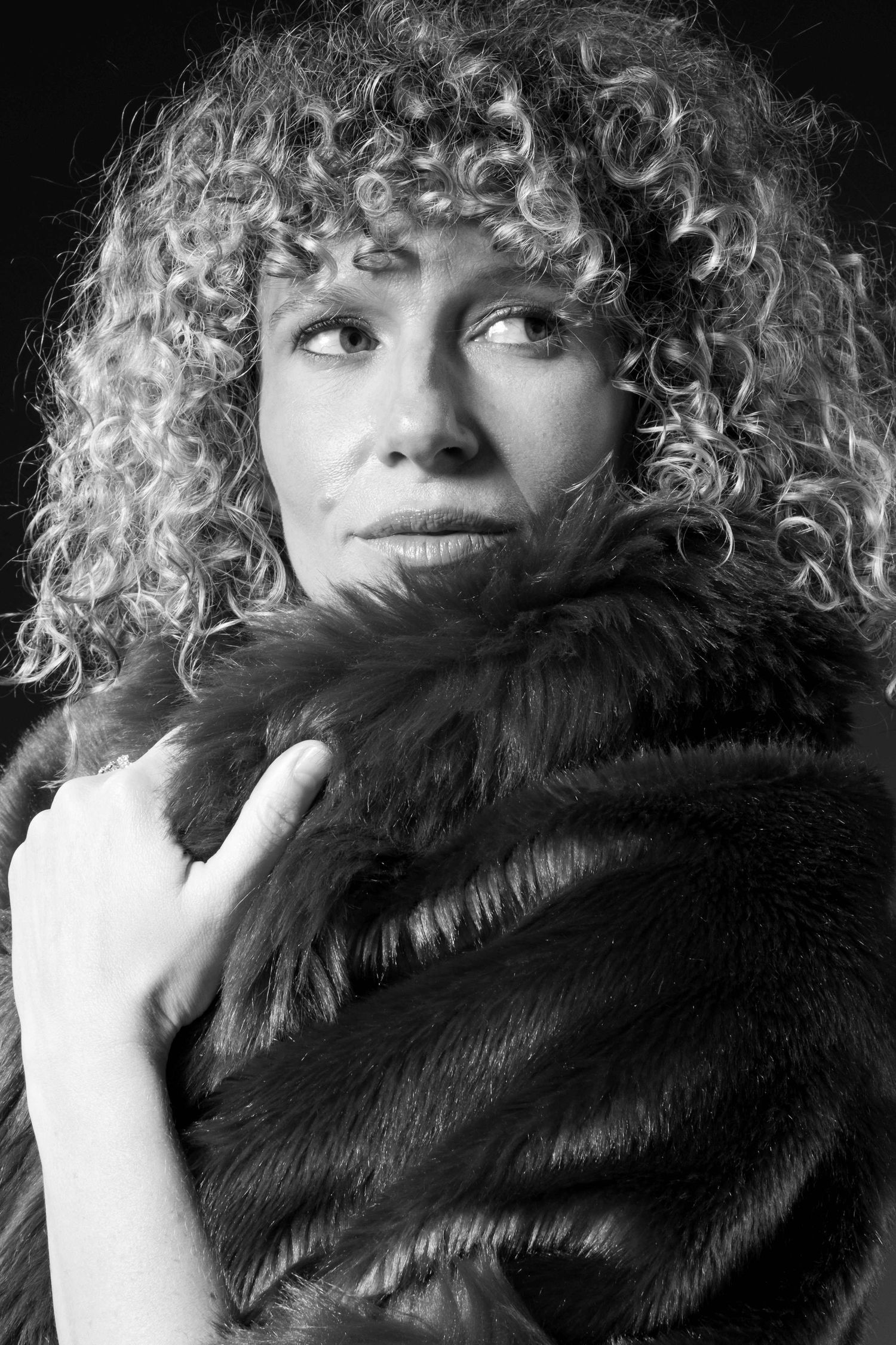 Black and white beauty portrait of Freeride World Tour snowboarder Michaela Davis-Meehan wearing a faux fur wrap in a Sydney studio.