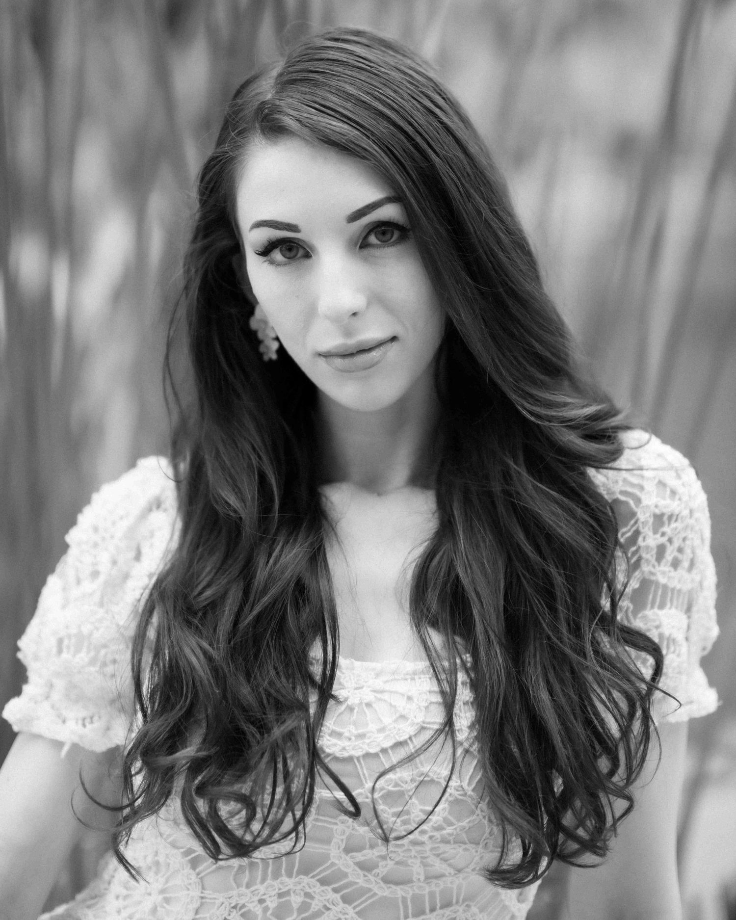 Black and white portrait of a woman in a lace dress surrounded by greenery in a Burwood park.