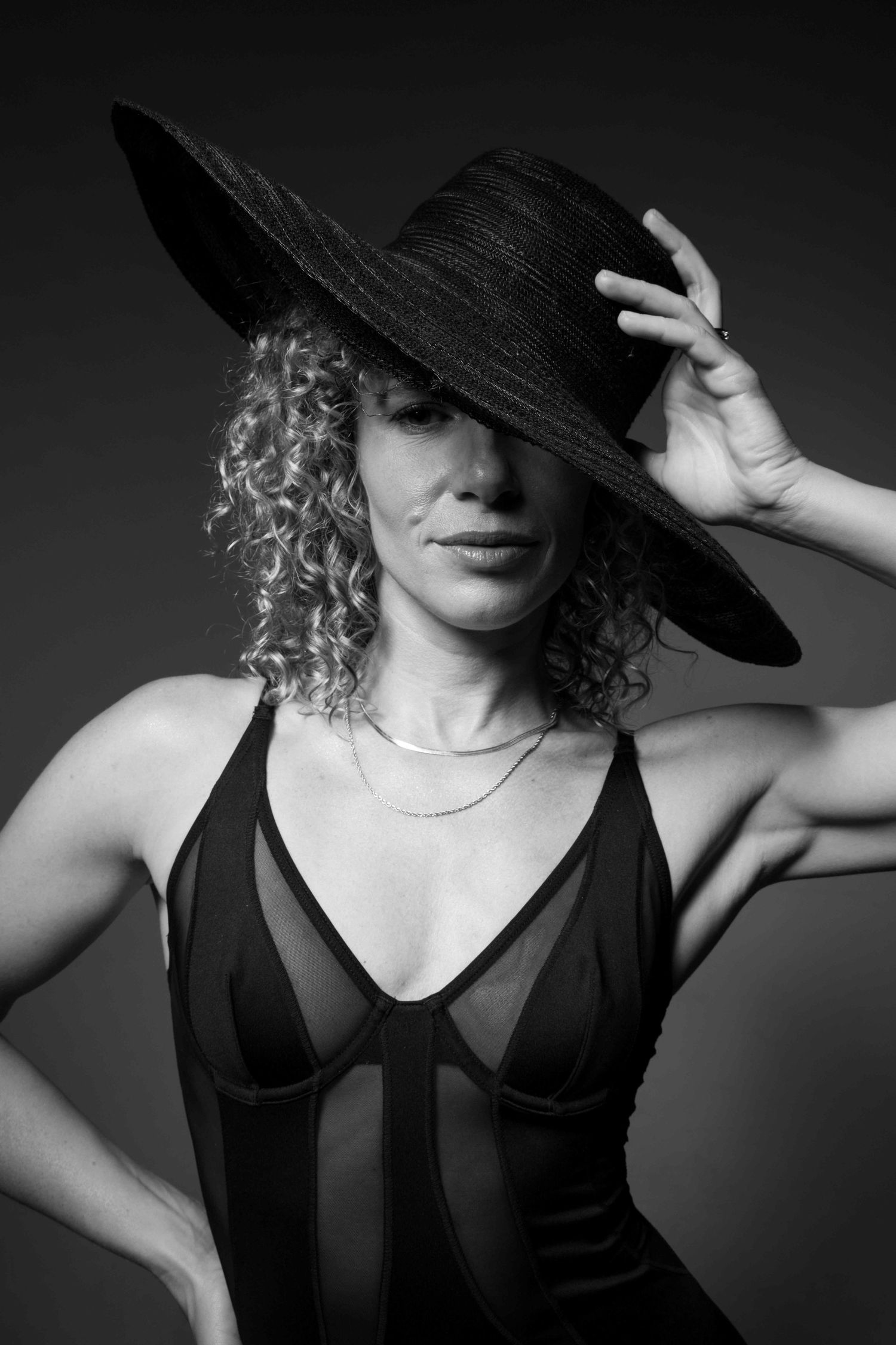 Editorial black and white portrait of Freeride World Tour snowboarder Michaela Davis-Meehan wearing a wide-brim hat in a Sydney studio.