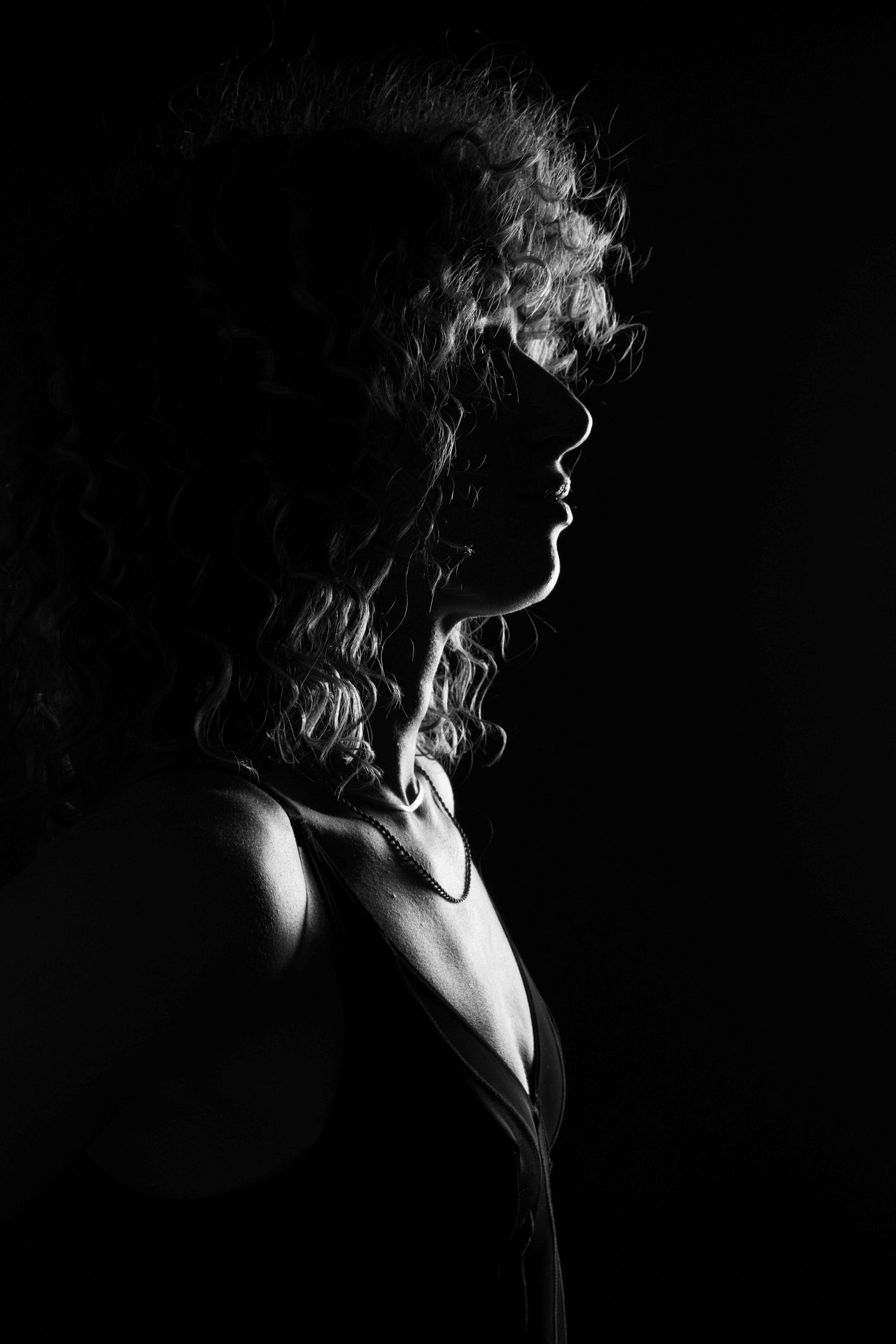 Black and white silhouette portrait of Freeride World Tour snowboarder Michaela Davis-Meehan using dramatic studio lighting.