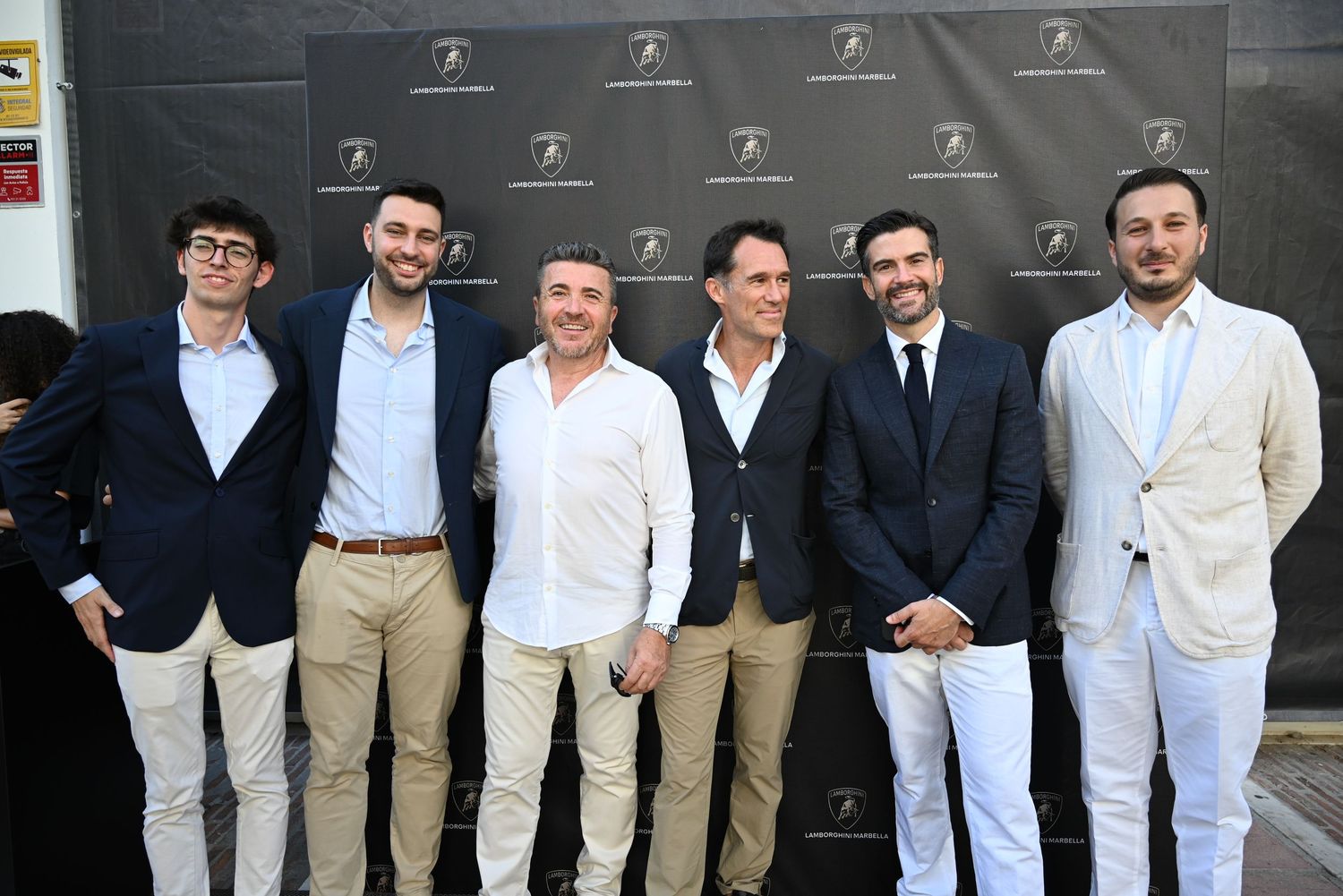 Guests posing at the entrance of the Lamborghini Marbella showroom, capturing the elegance and exclusivity of the event.