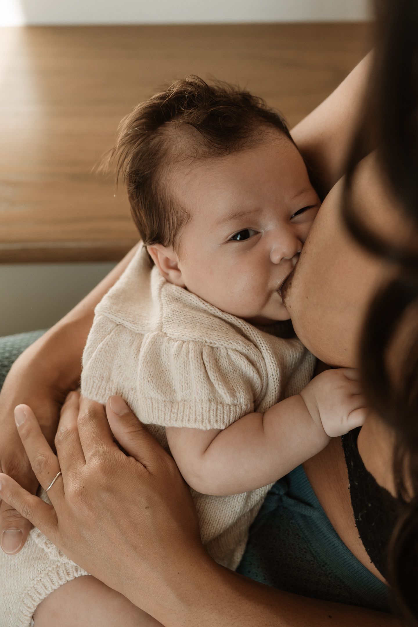 A tender moment between parent and baby in warm sepia tones showing a series of gentle kisses and embraces.