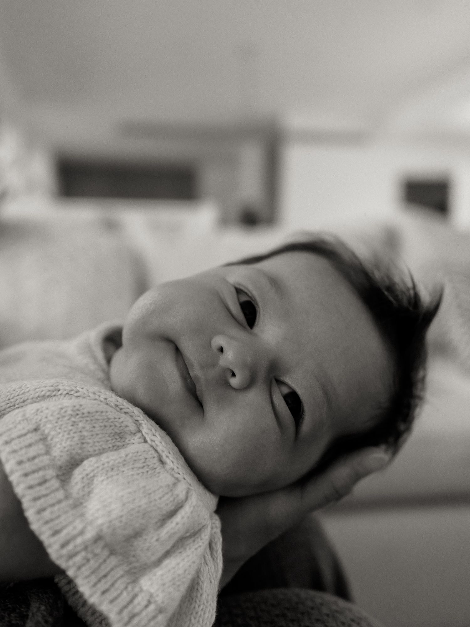 A series of black and white portrait photographs showing someone wearing a knit sweater in various reclining poses.