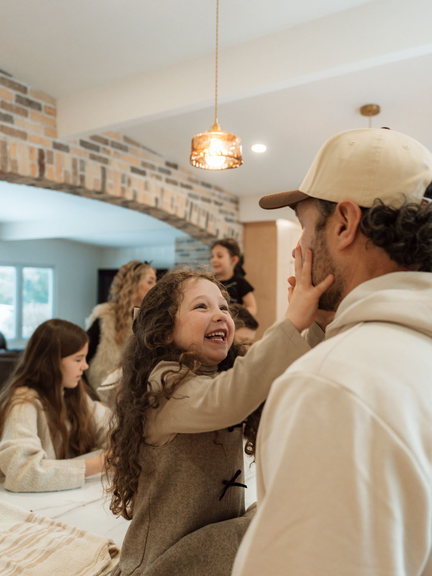 A candid series of laughing moments captured between people in a bright interior space with brick accent walls.