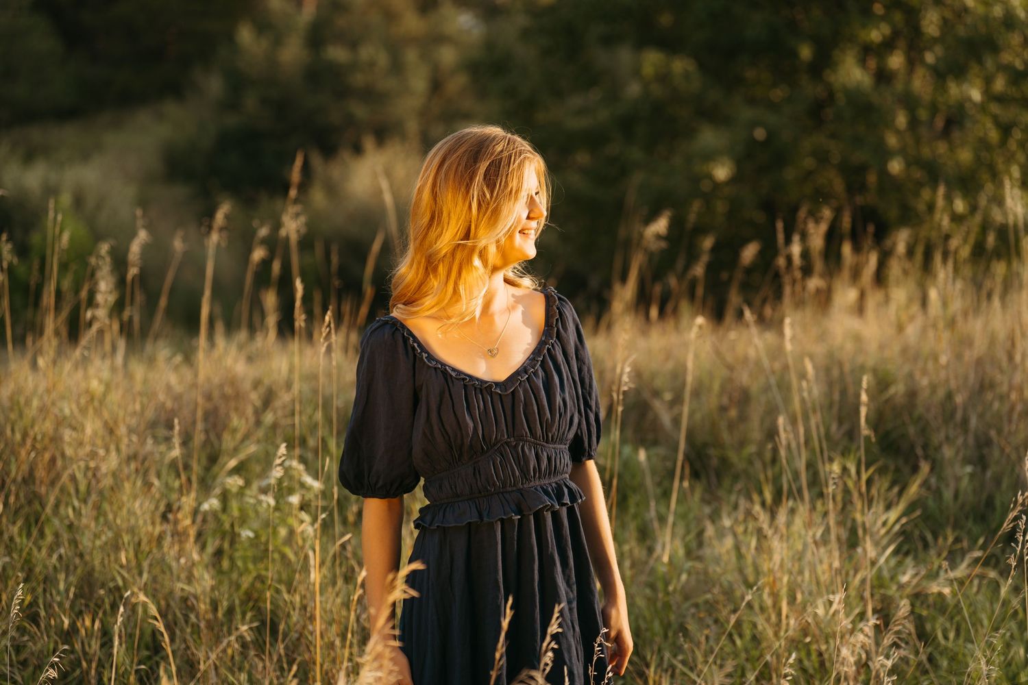 Portrait session in tall grass field during golden sunset light.