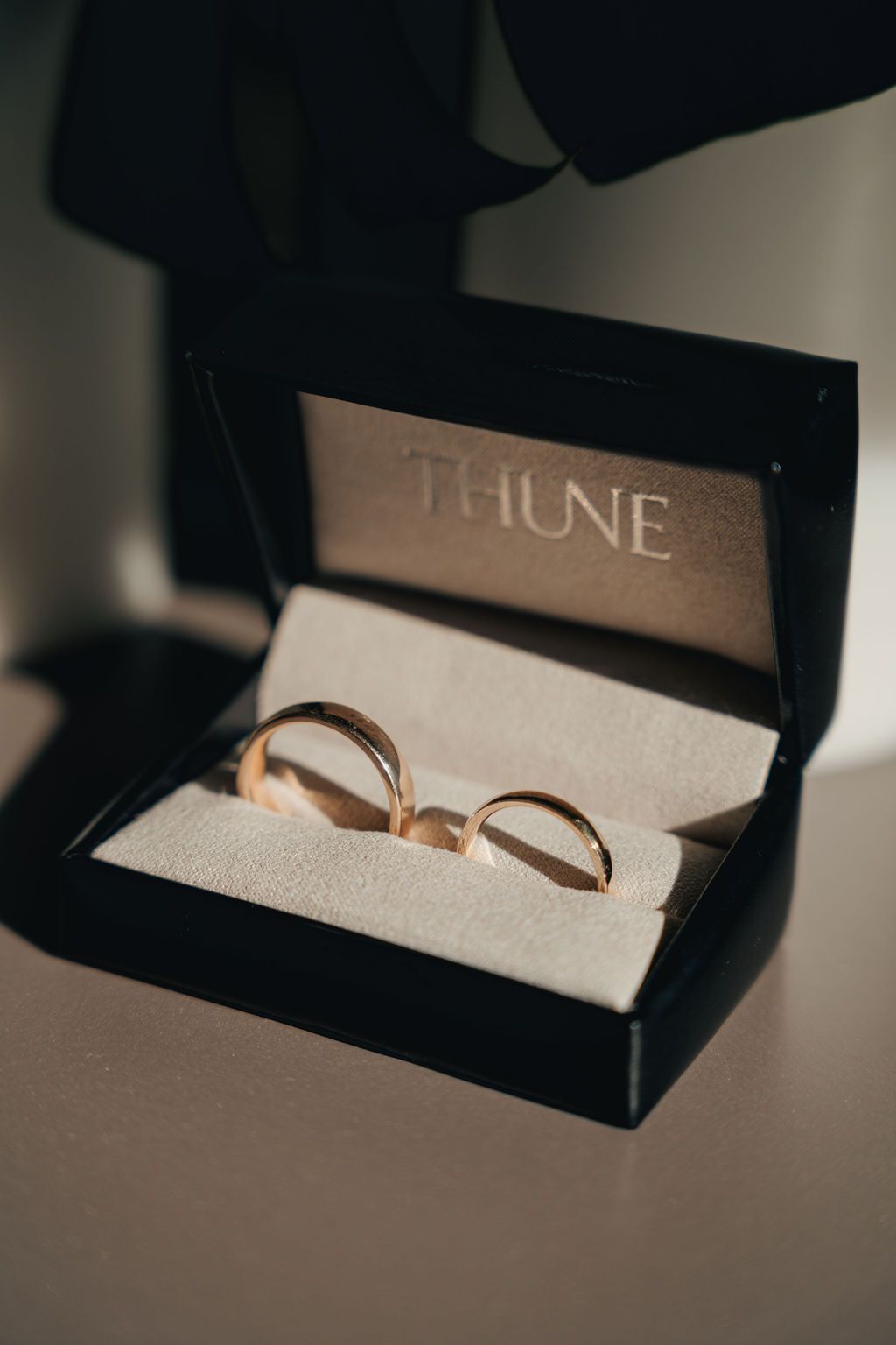 Close-up view of a gold ring resting on an open book page in dramatic lighting.