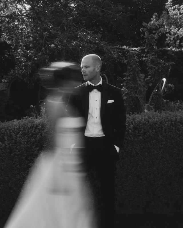 A black and white wedding photo series showing a couple in motion against a dark outdoor background with trees.