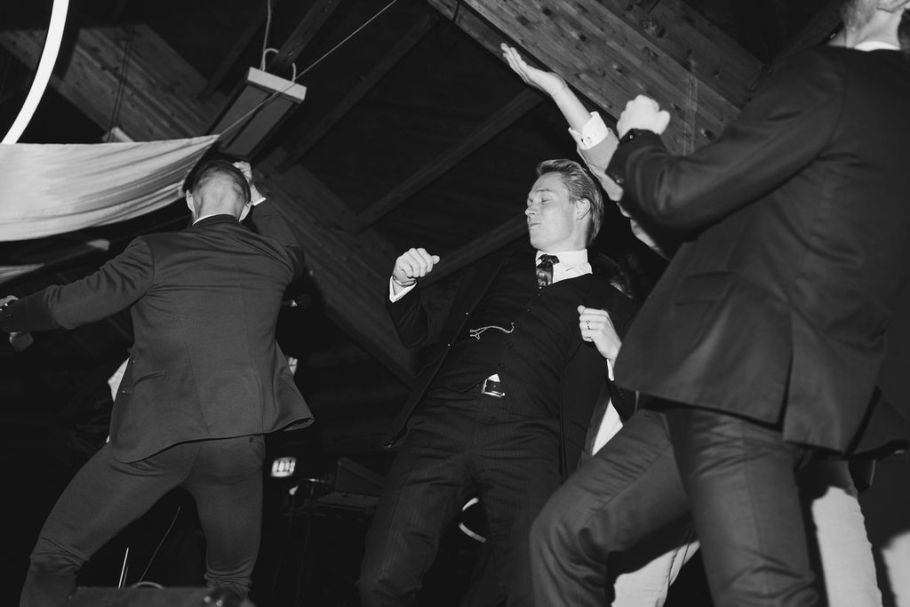Black and white vintage photograph showing dancers performing energetic swing dance moves on a dance floor.