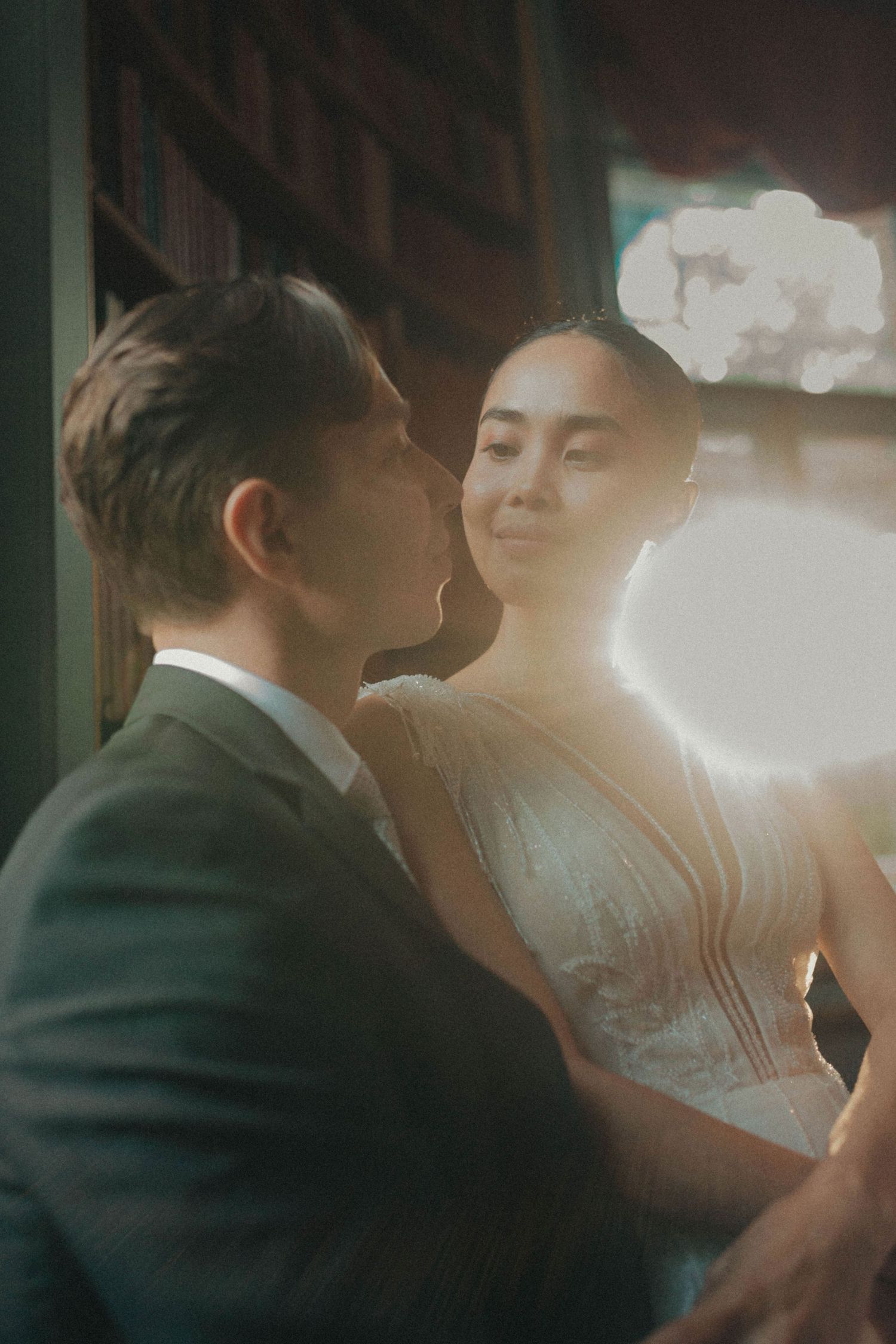 A romantic couple in wedding attire share intimate moments in a series of dimly lit, atmospheric photographs.