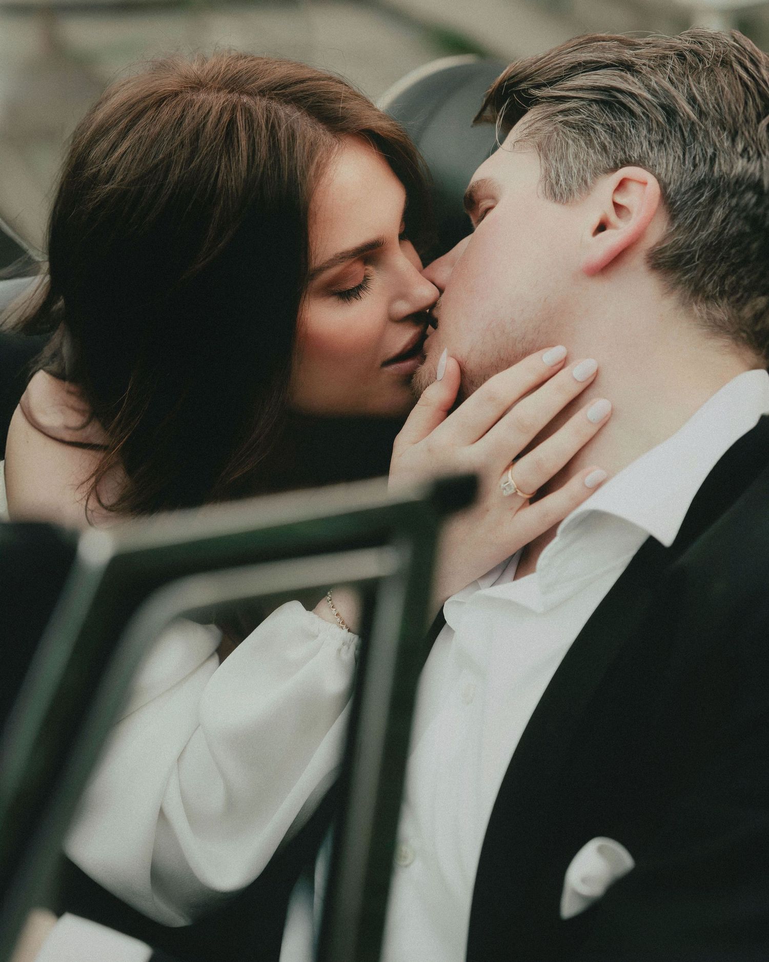 A romantic couple sharing an intimate kiss in a series of moody, black and white photographs.