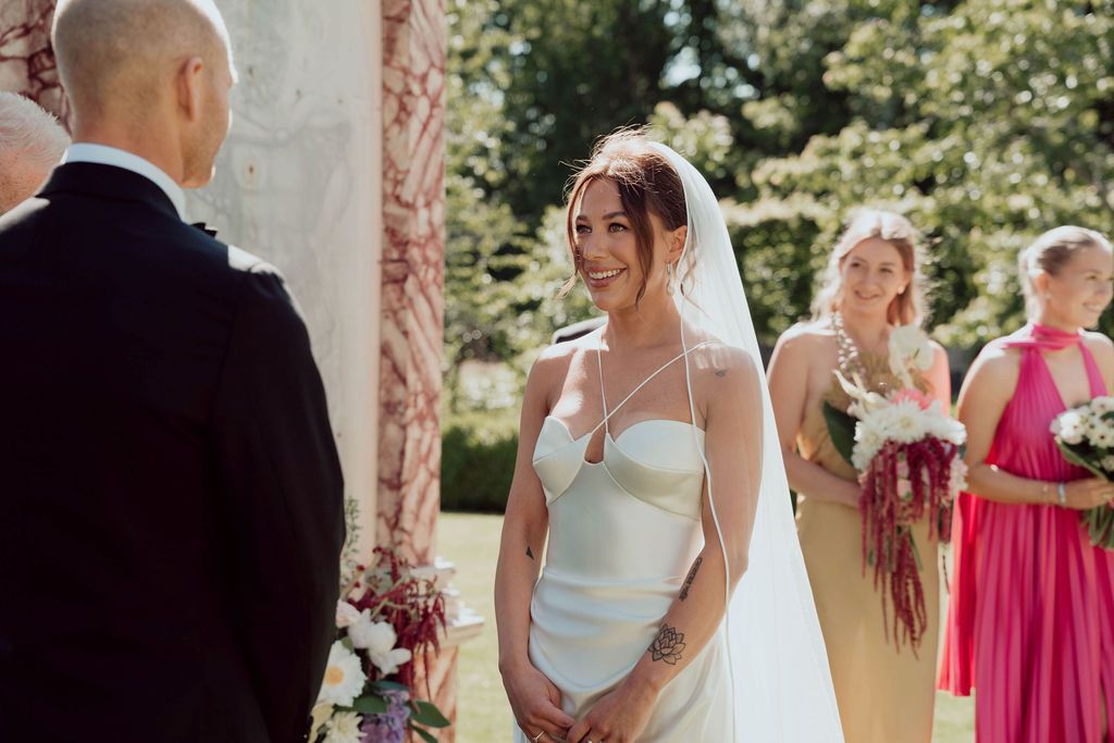 A collection of wedding party photos taken outdoors with bridesmaids in pink dresses under a stone archway.