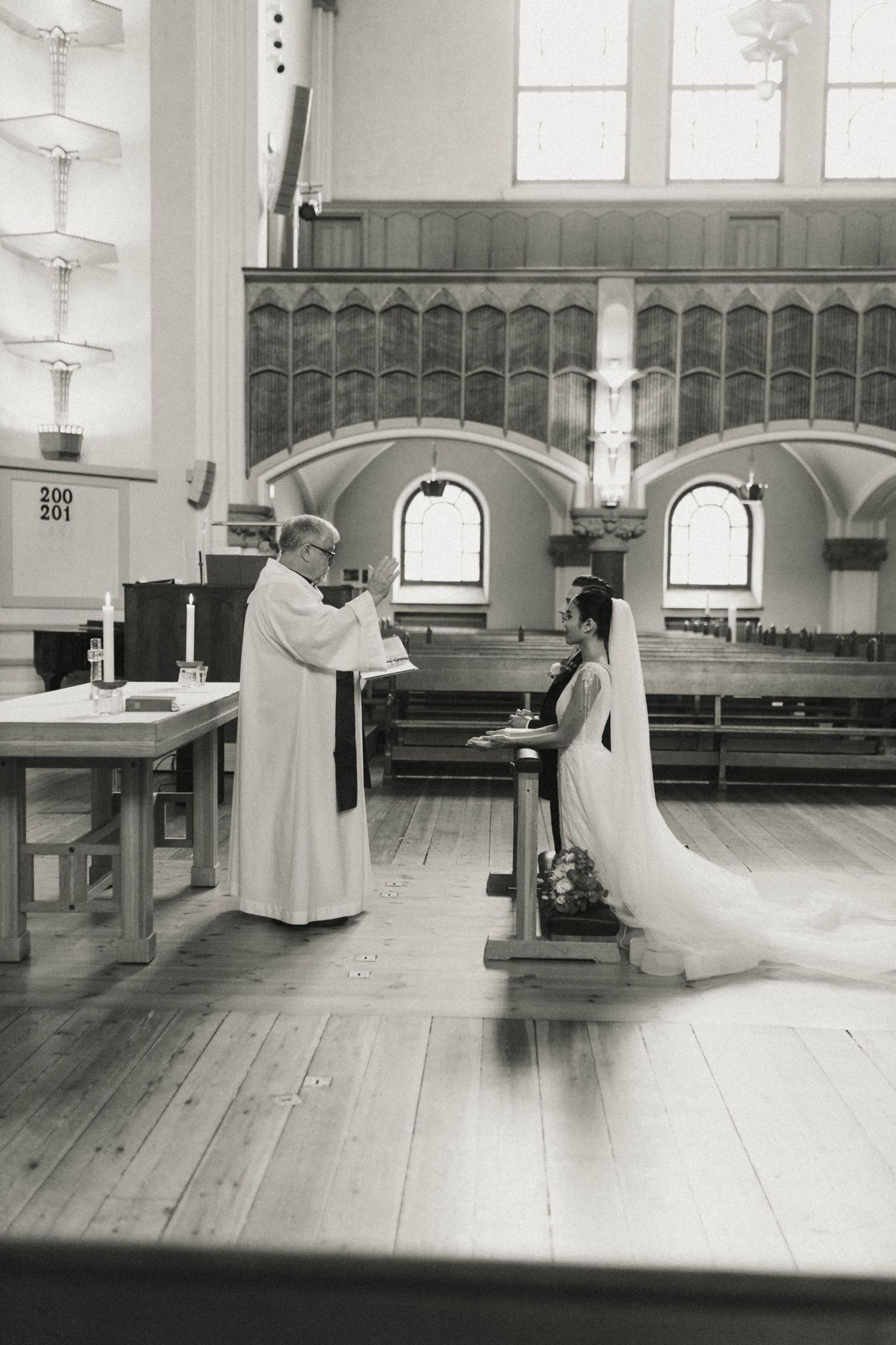 A sequence of black and white photos showing a person in religious attire kneeling and praying in a church sanctuary.