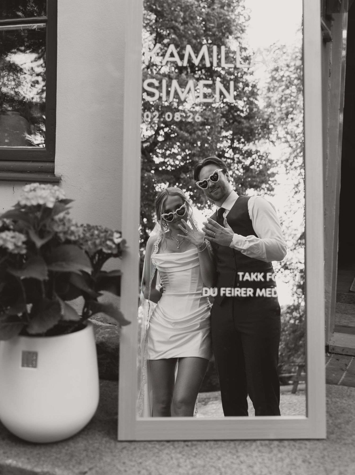 Black and white reflection of bride and groom in wedding welcome mirror sign.