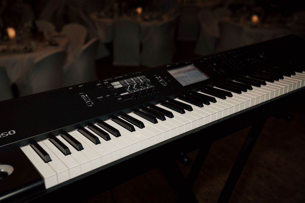 Close-up view of black piano keys on a grand piano keyboard in low light conditions.