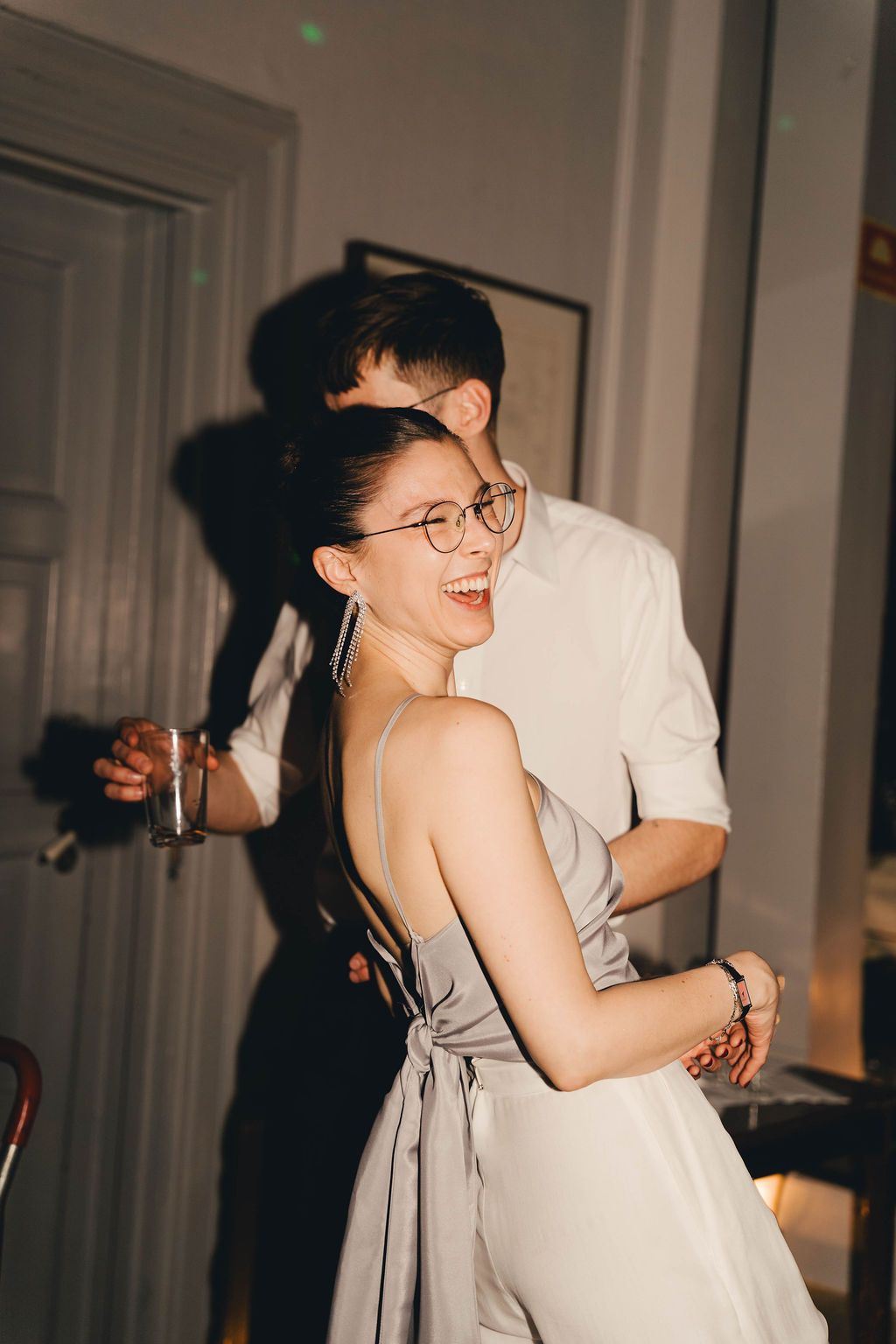 Two people share a joyful moment together while dancing in a bright indoor setting.