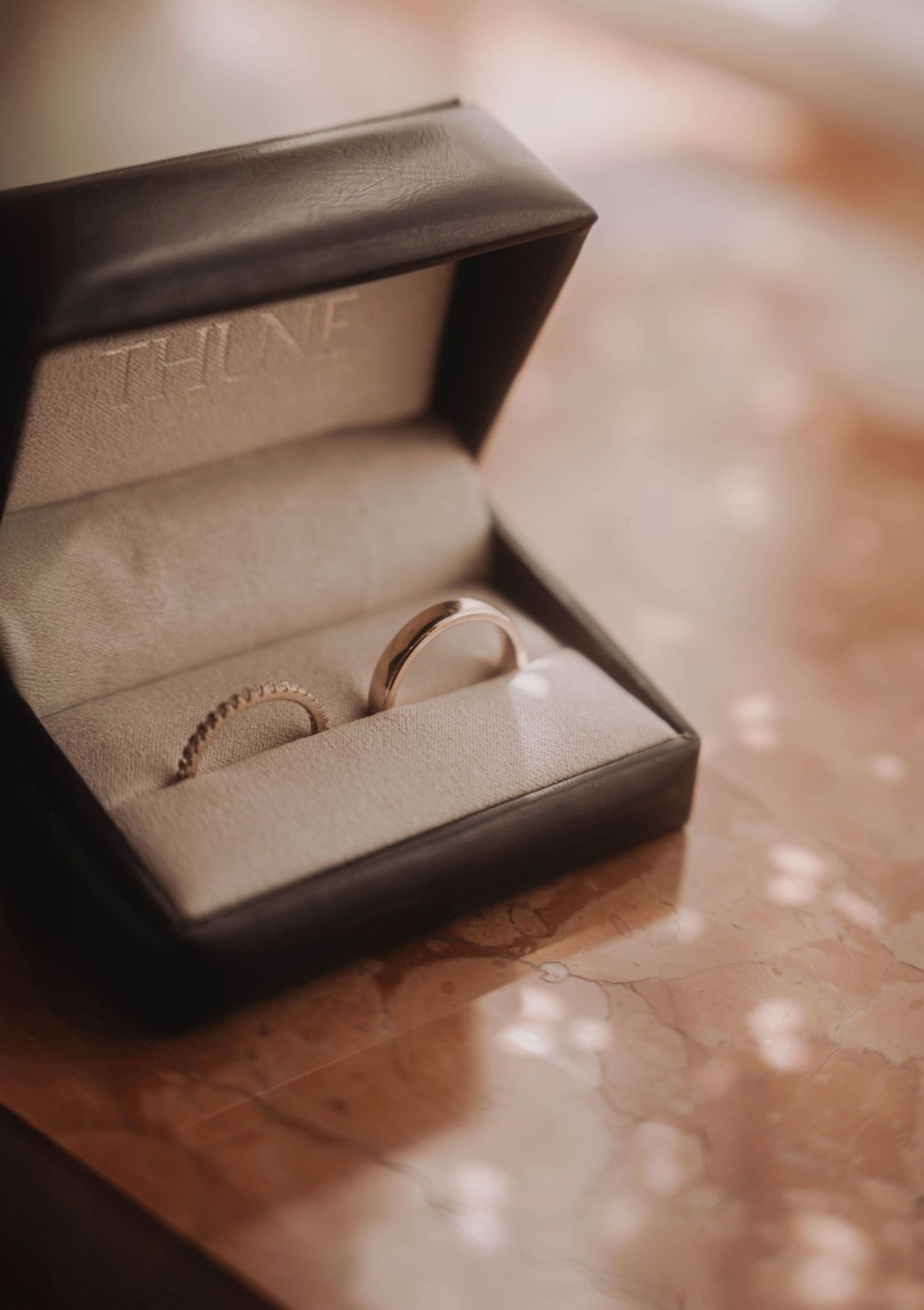 Wedding rings displayed in an elegant jewelry box with soft focus lighting.