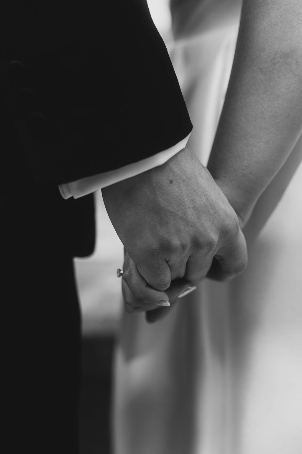 A black and white close-up series showing two hands clasped together in a romantic gesture.