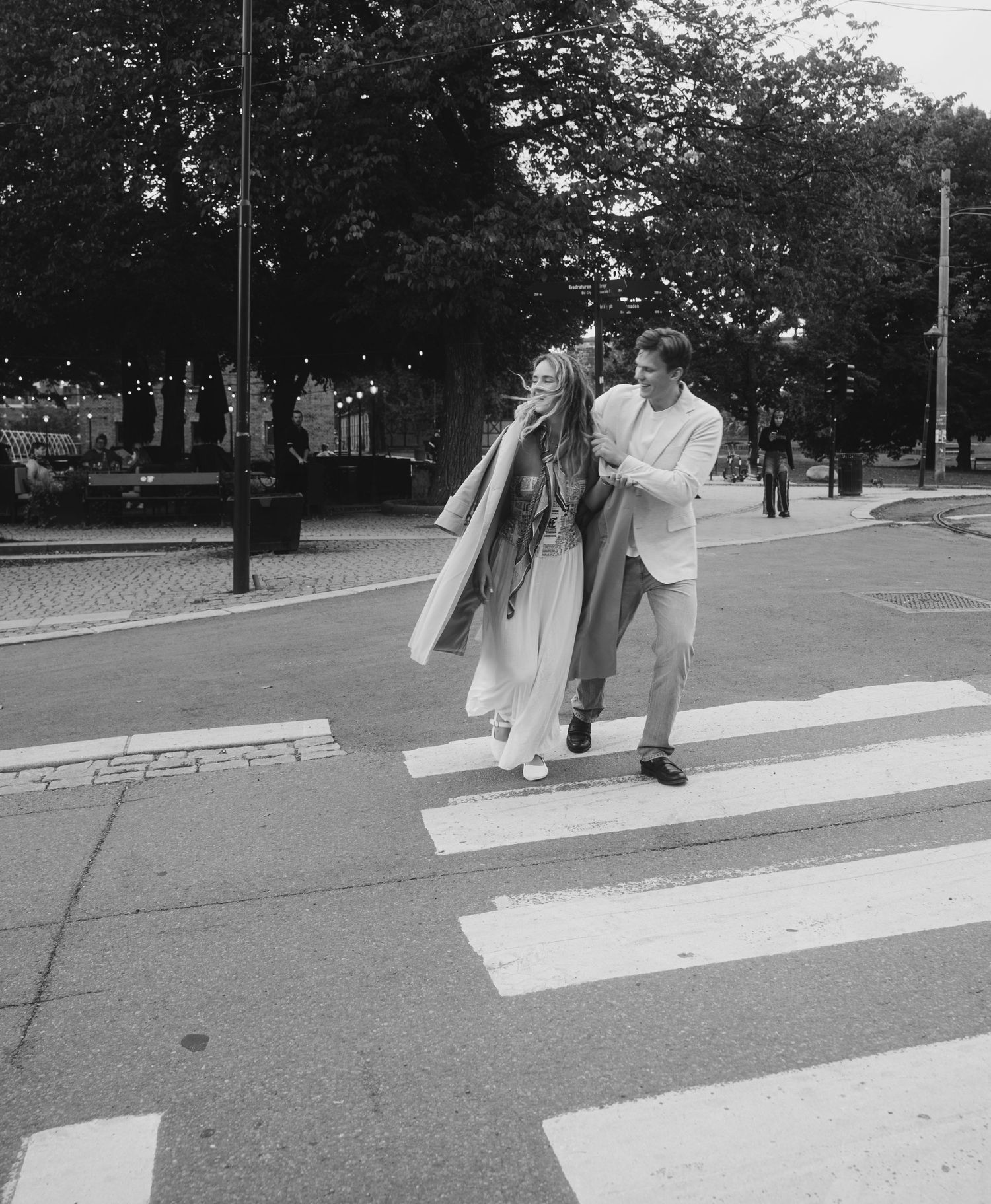 A sequence of five black and white photographs showing someone bowling on a street crosswalk.