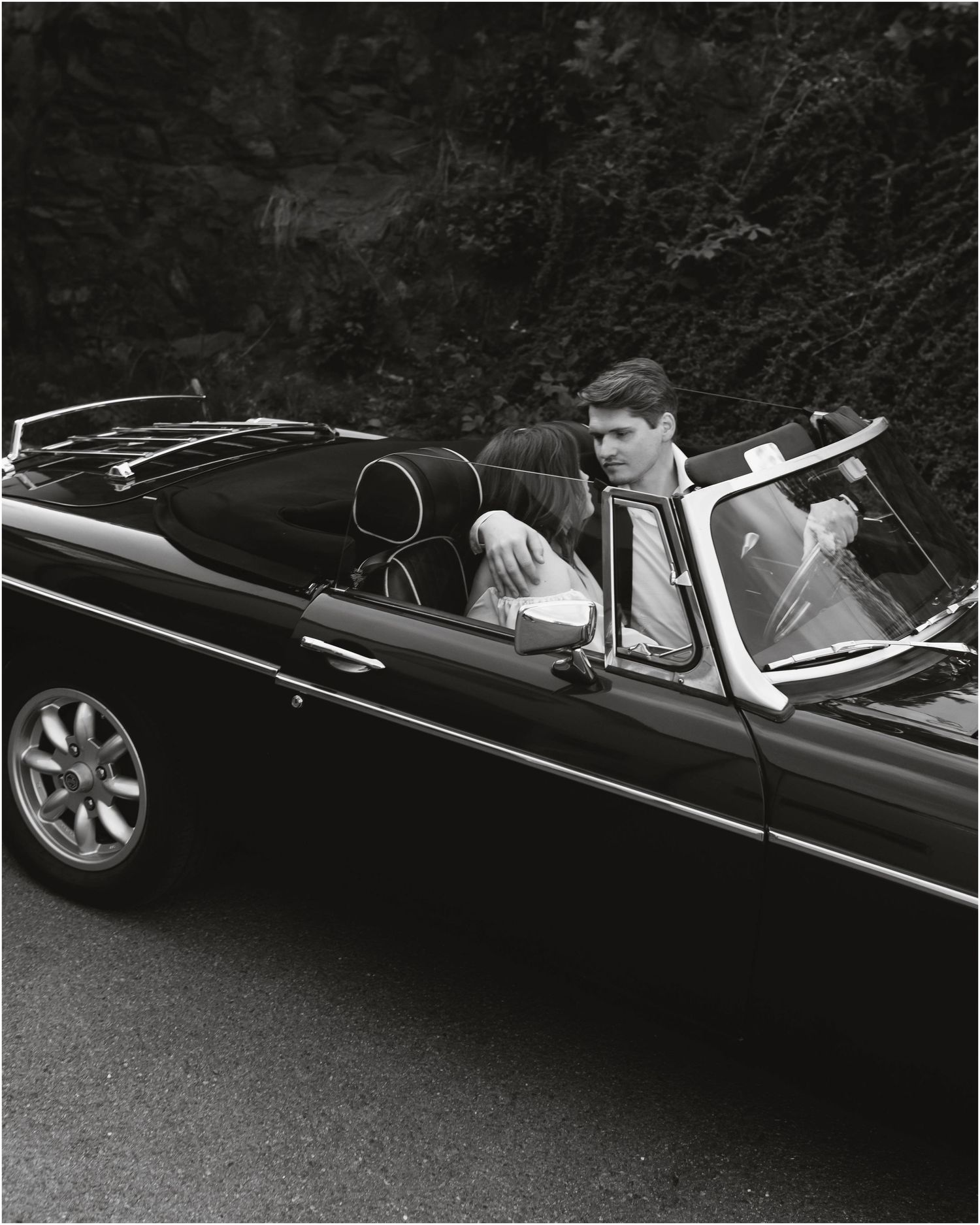 A sequence of black and white photos showing a convertible car from different angles parked on an asphalt surface.