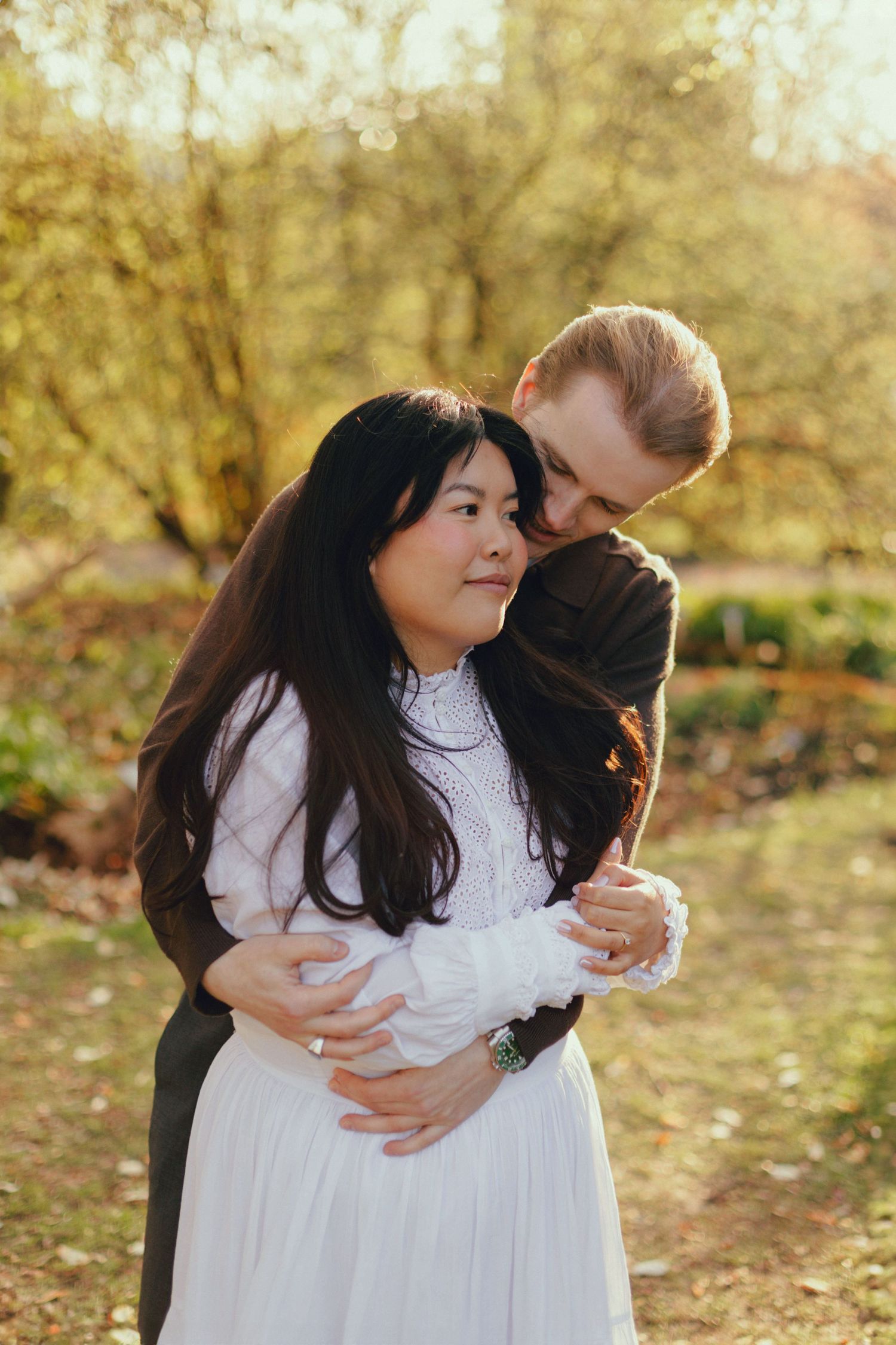 A romantic autumn outdoor photo sequence shows a couple embracing tenderly among fallen leaves and golden light.