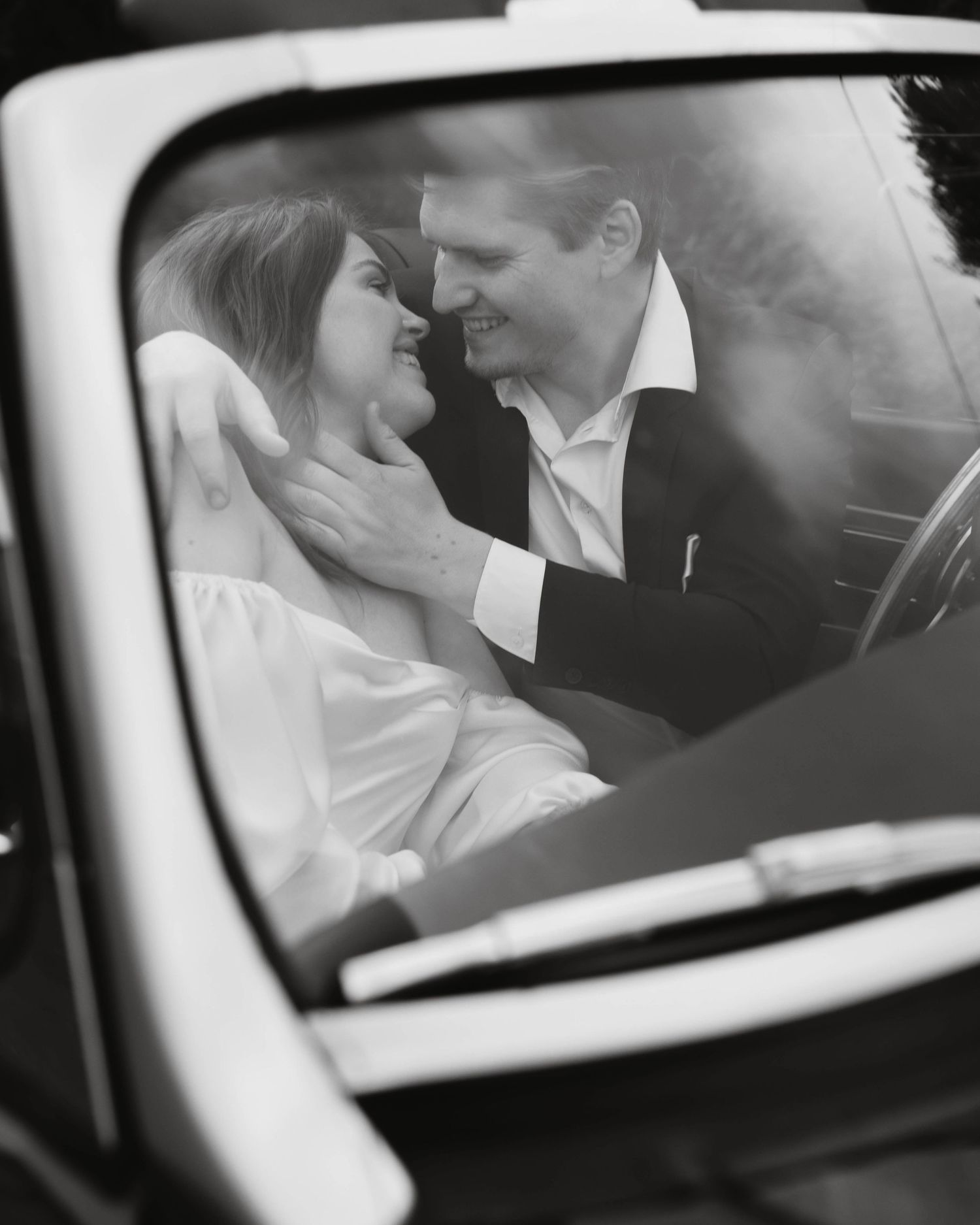 A romantic black and white photo series showing a couple sharing intimate moments through a car window.