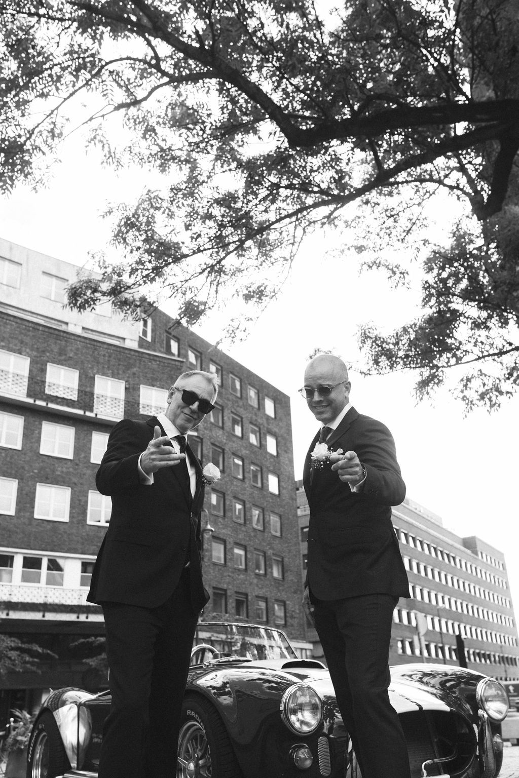 A sequence of black and white photos shows a couple dancing together outdoors near brick buildings and parked cars.