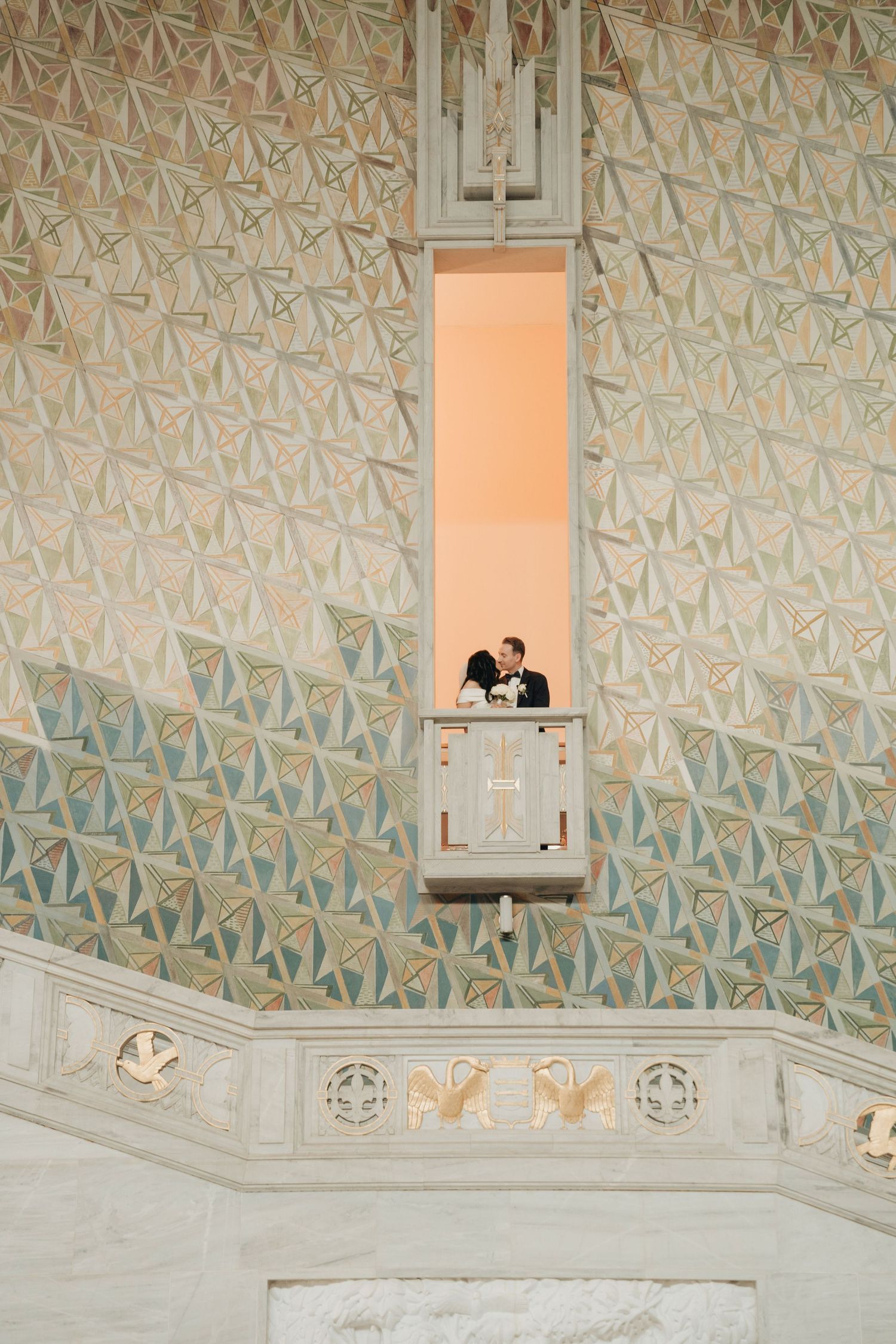 Architectural detail showing ornate geometric wall patterns and a small window opening with decorative stonework in a historic building.