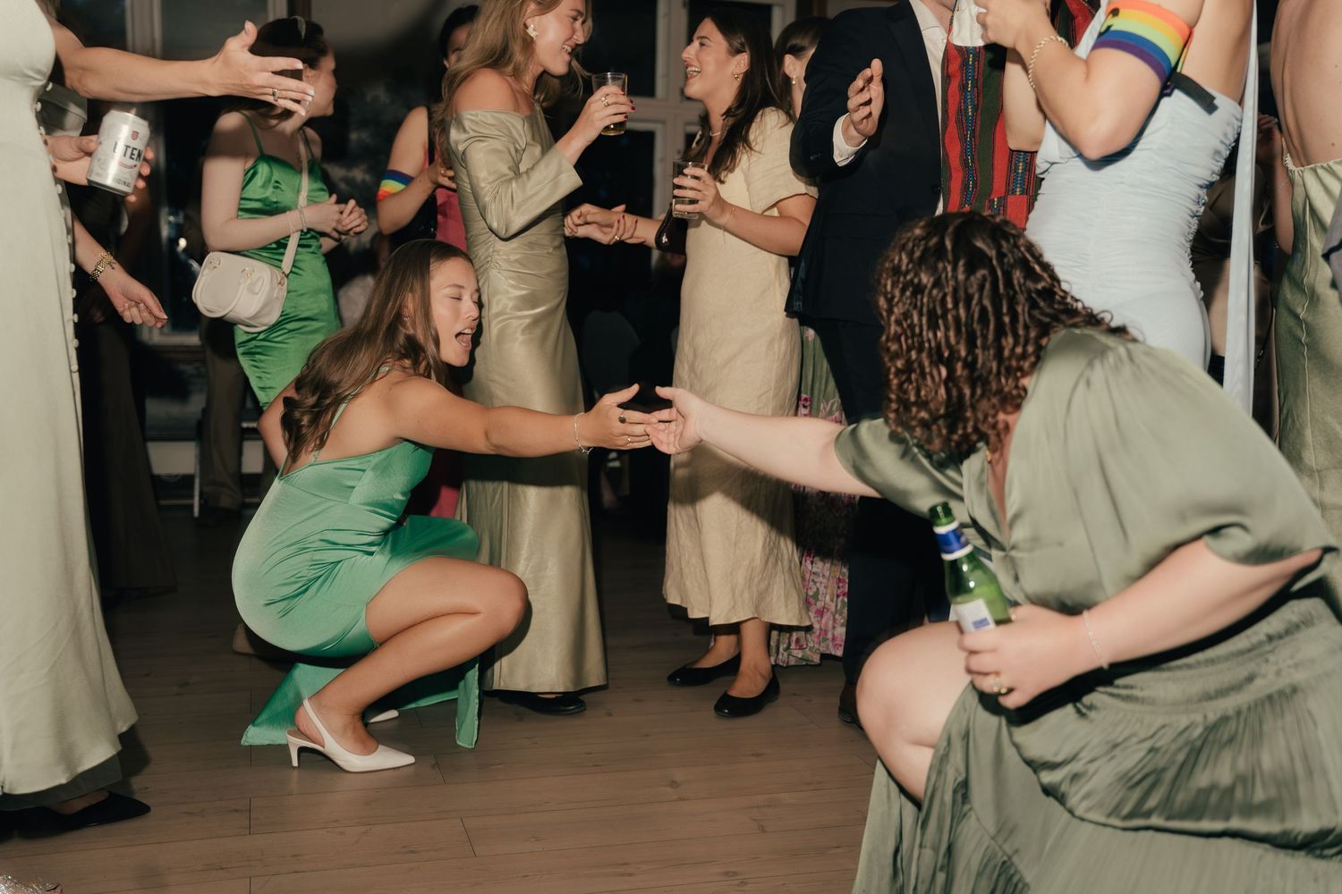 Wedding guests dancing and celebrating on the dance floor at evening reception.