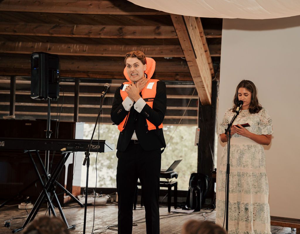 A couple shares their first dance at a rustic wedding reception venue with wooden beams and natural light.