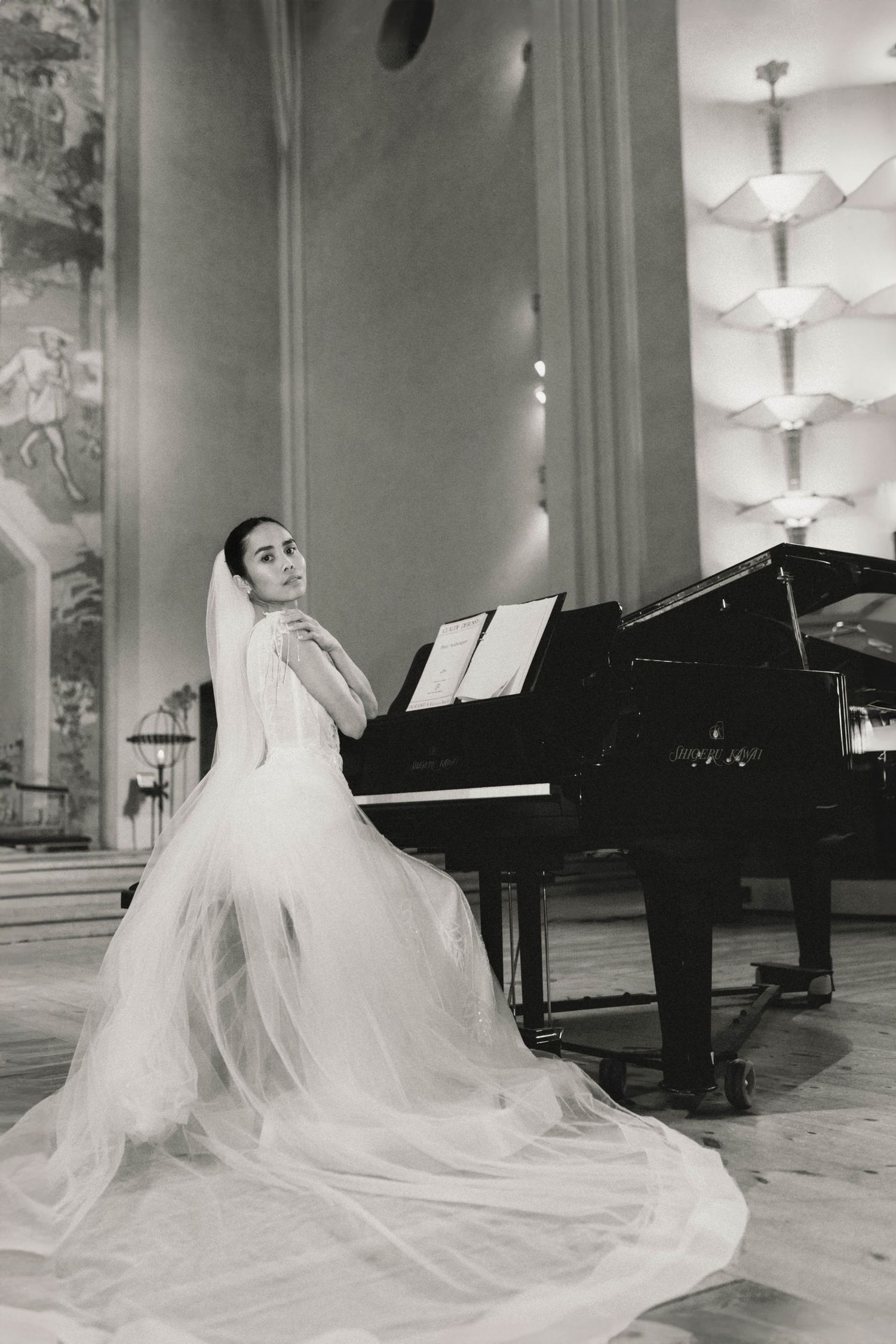 A dramatic black and white photo series showing a flowing wedding dress and grand piano in an elegant room.