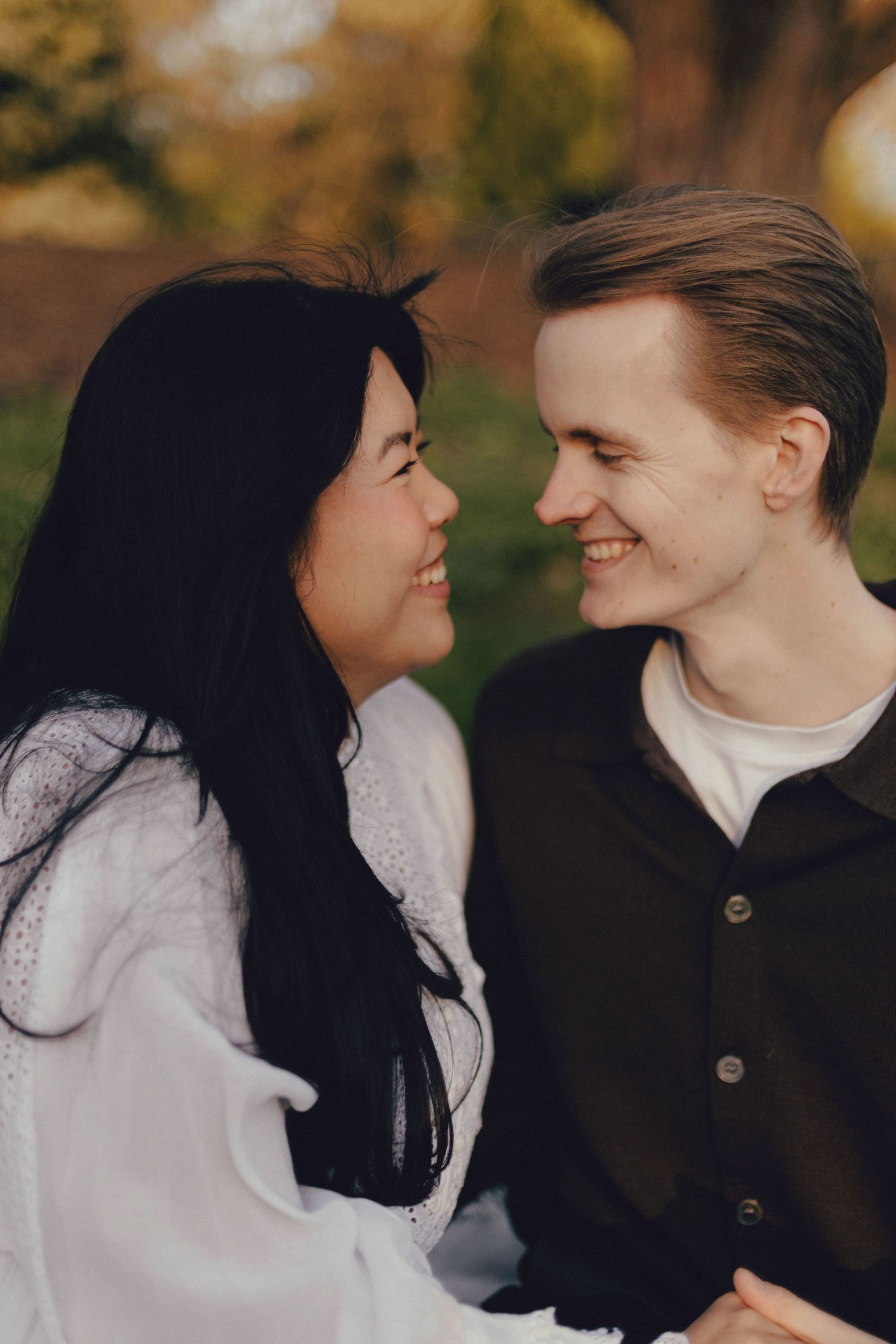 A couple shares intimate moments in a series of romantic outdoor portraits with autumn foliage in the background.
