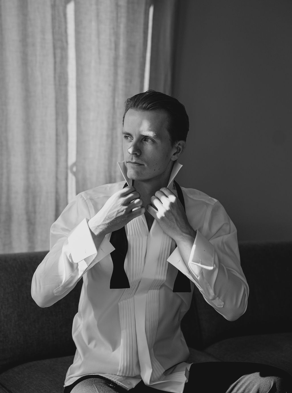 A sequence of black and white photos shows someone in a white dress shirt adjusting their collar and bow tie.