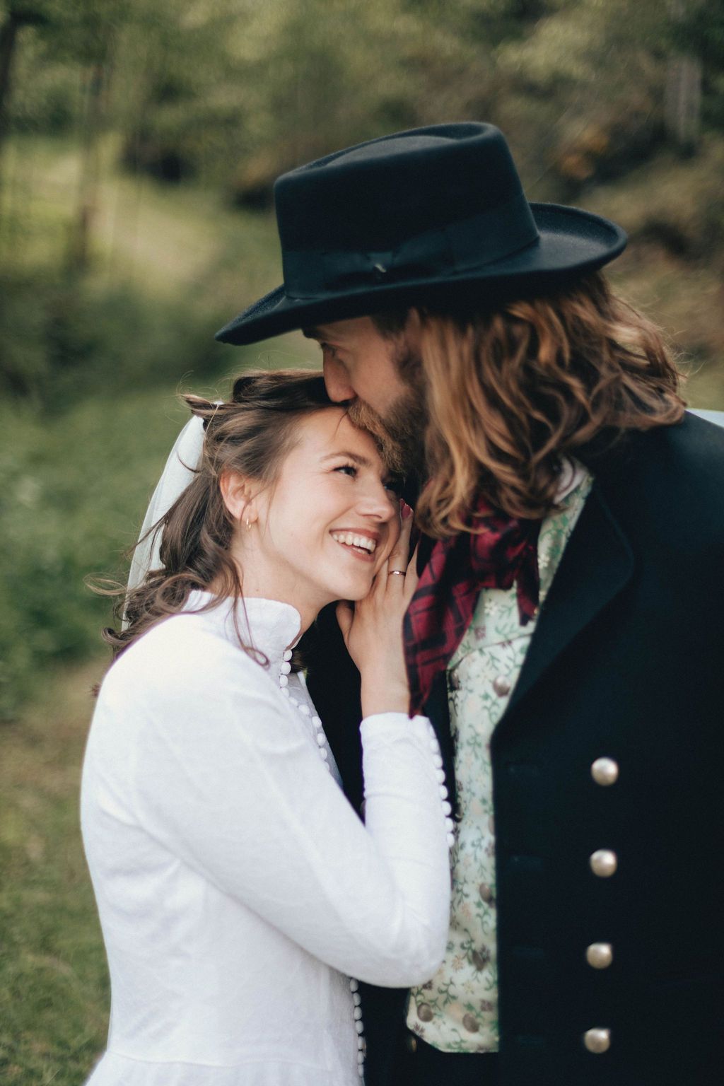 A romantic outdoor photoshoot showing a couple in black and white attire sharing intimate moments together in nature.
