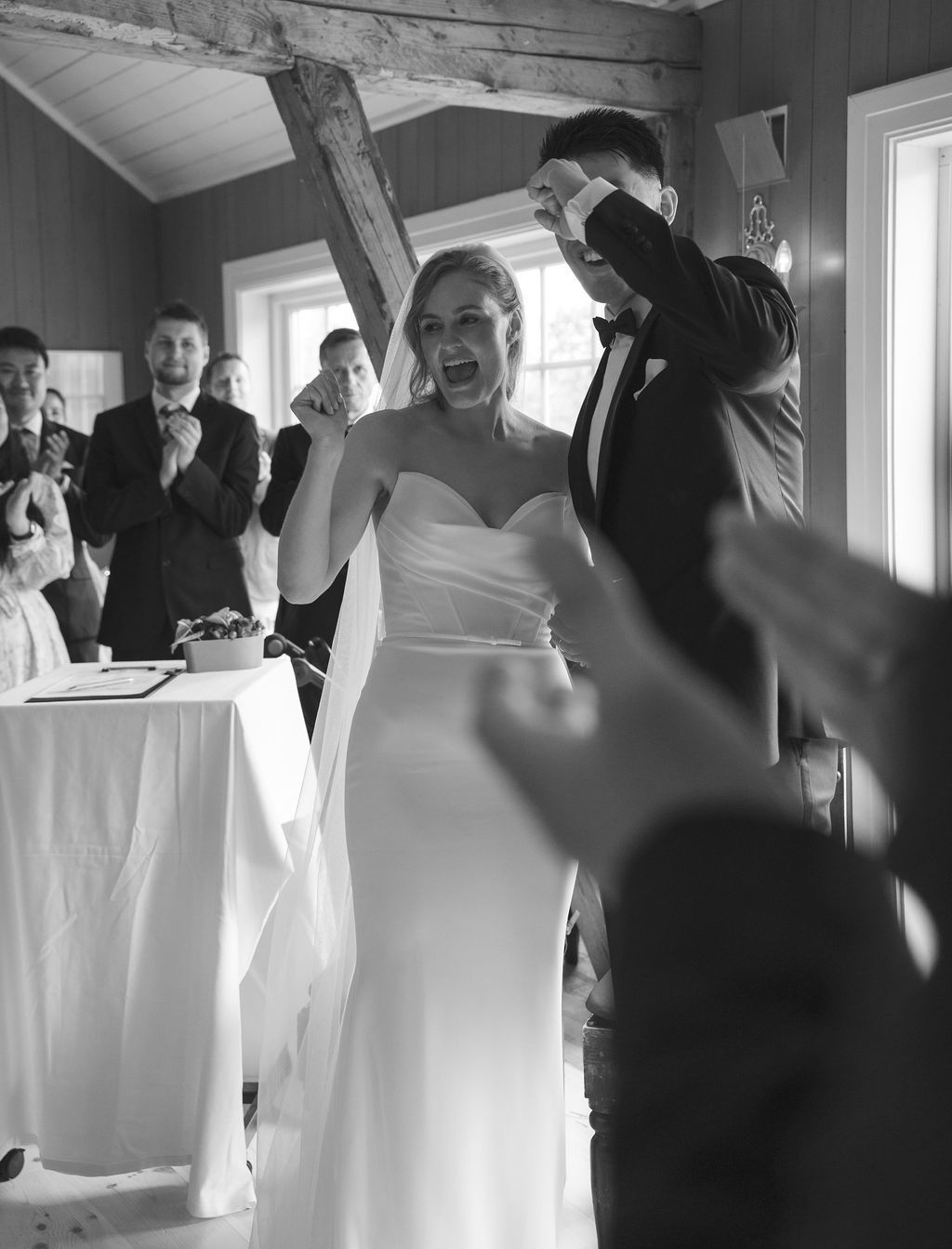 Black and white wedding photo sequence showing a couple getting ready and celebrating in a bright indoor space.