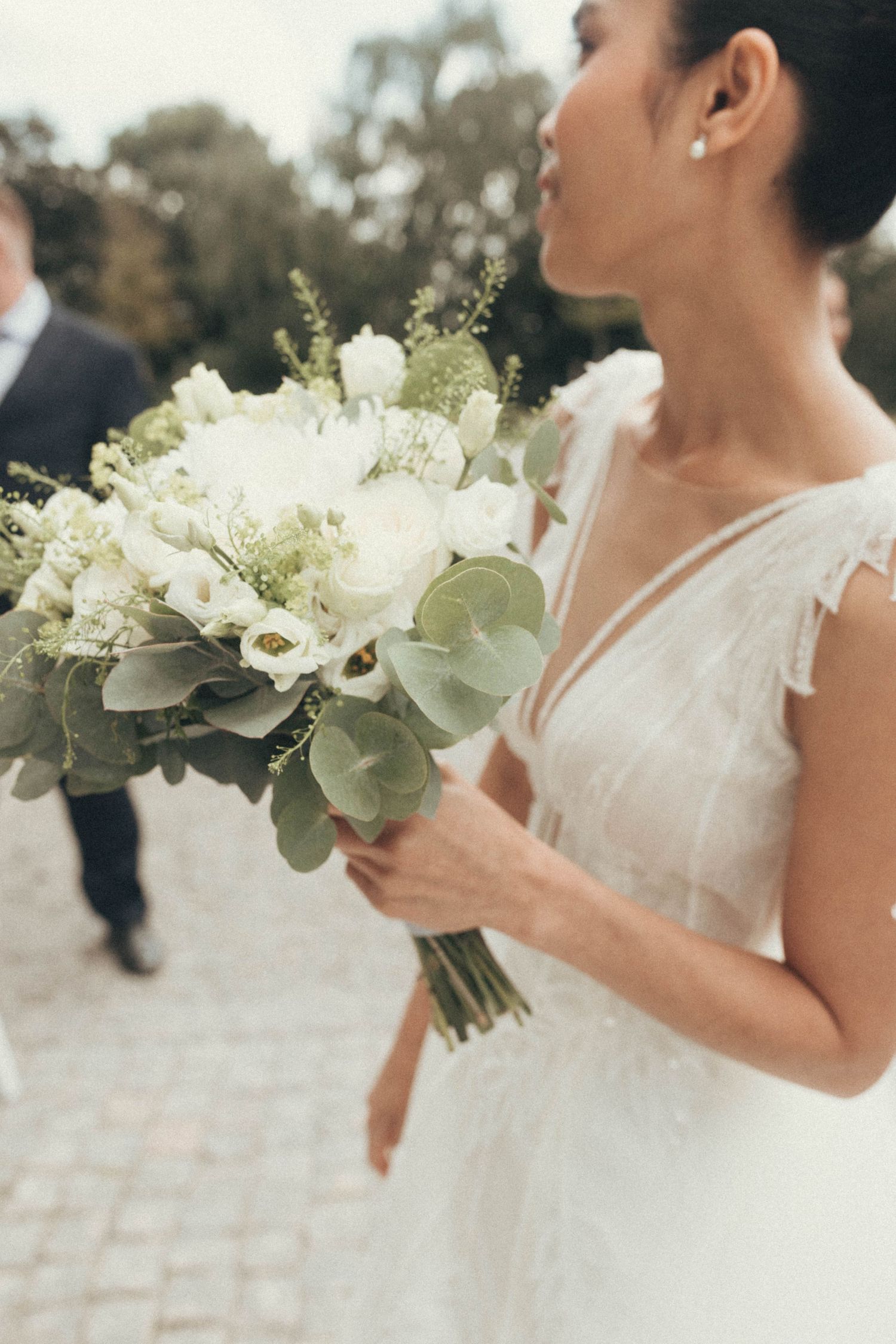 A series of close-up shots showing white bridal bouquets with eucalyptus leaves against a light background.