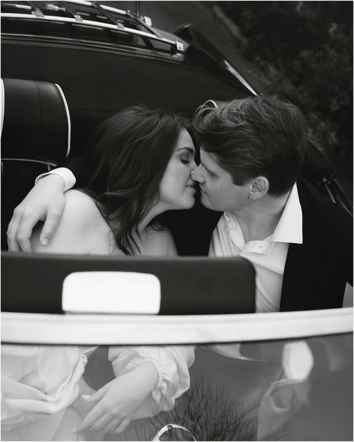 A black and white photo series showing a couple sharing intimate moments in a car.