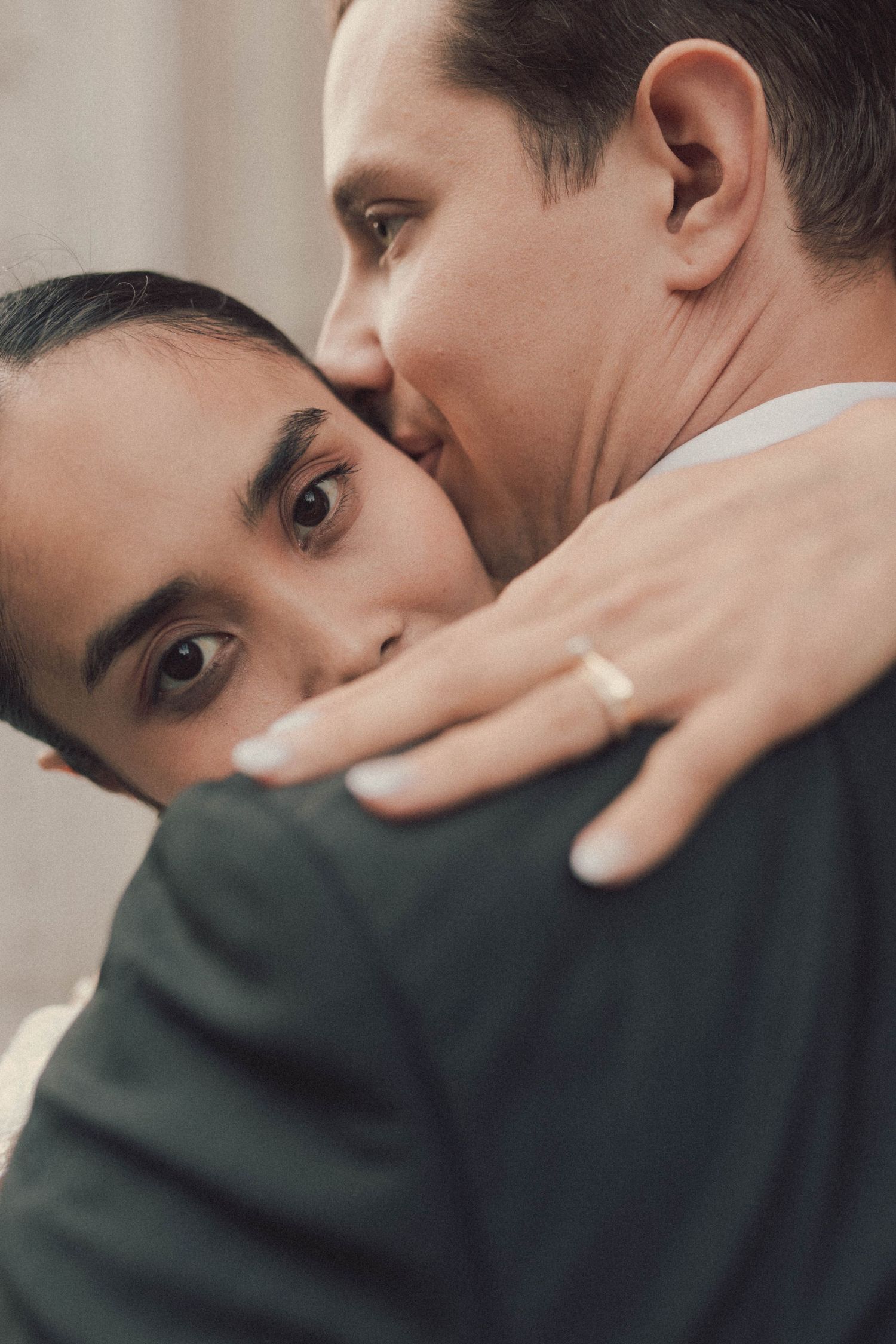 A series of intimate close-up shots showing two people in tender moments against a neutral background.