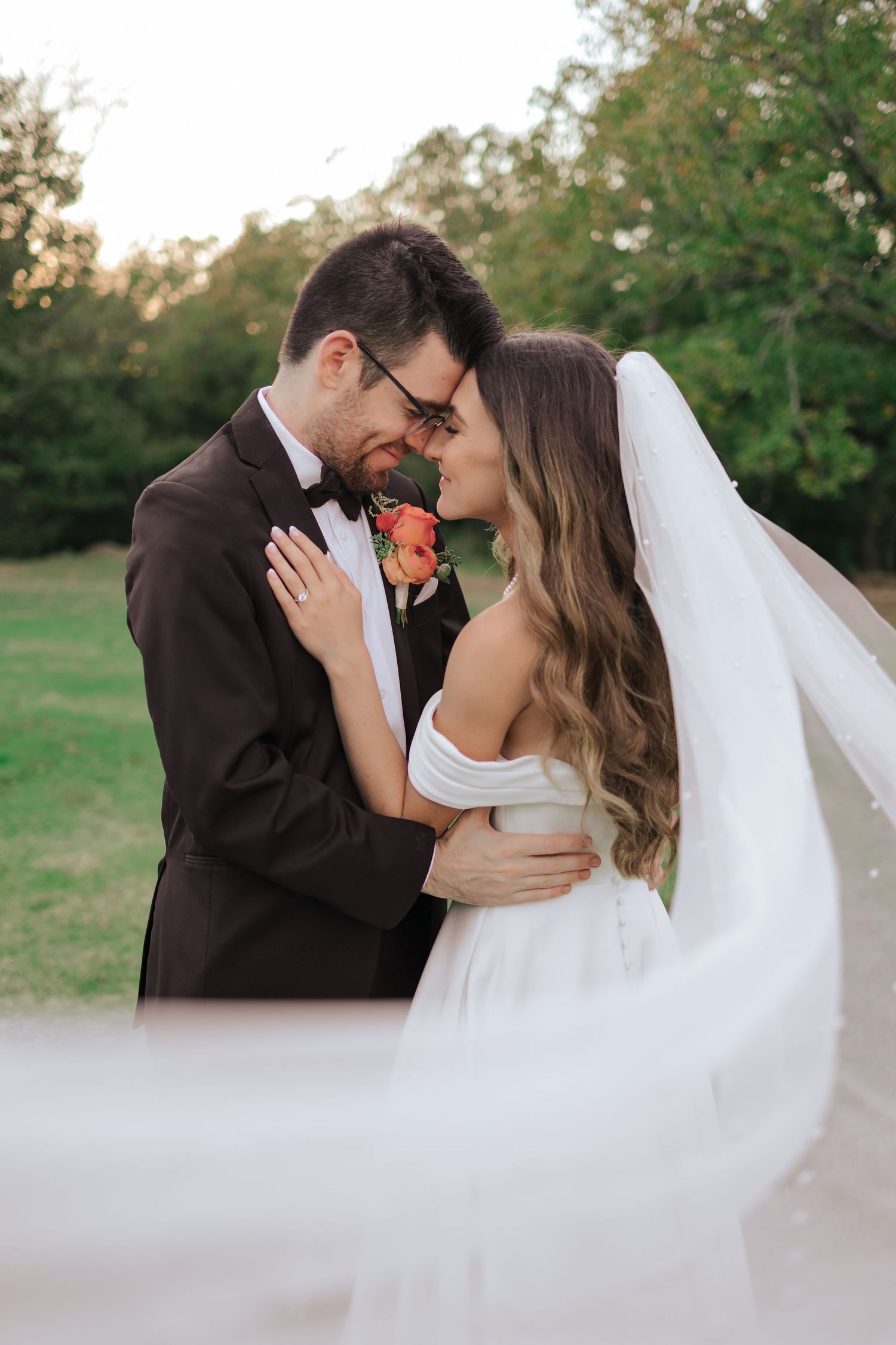 A romantic wedding couple shares intimate kisses in an outdoor garden setting during golden hour.