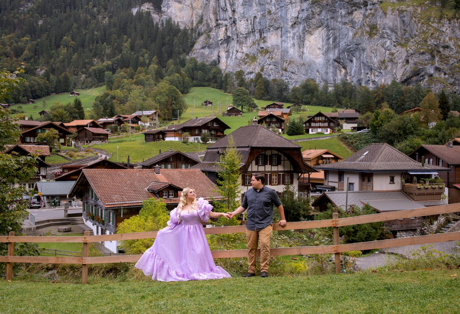 A scenic mountain village in Switzerland with traditional chalets and green meadows nestled in the Alps.