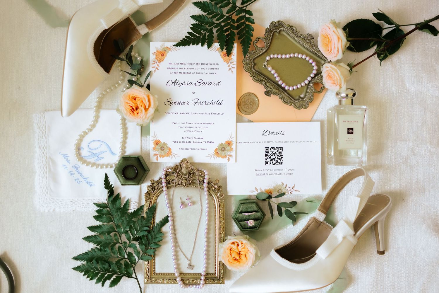 Elegant wedding stationery flatlay with peach roses, greenery, and delicate calligraphy invitations on white background.