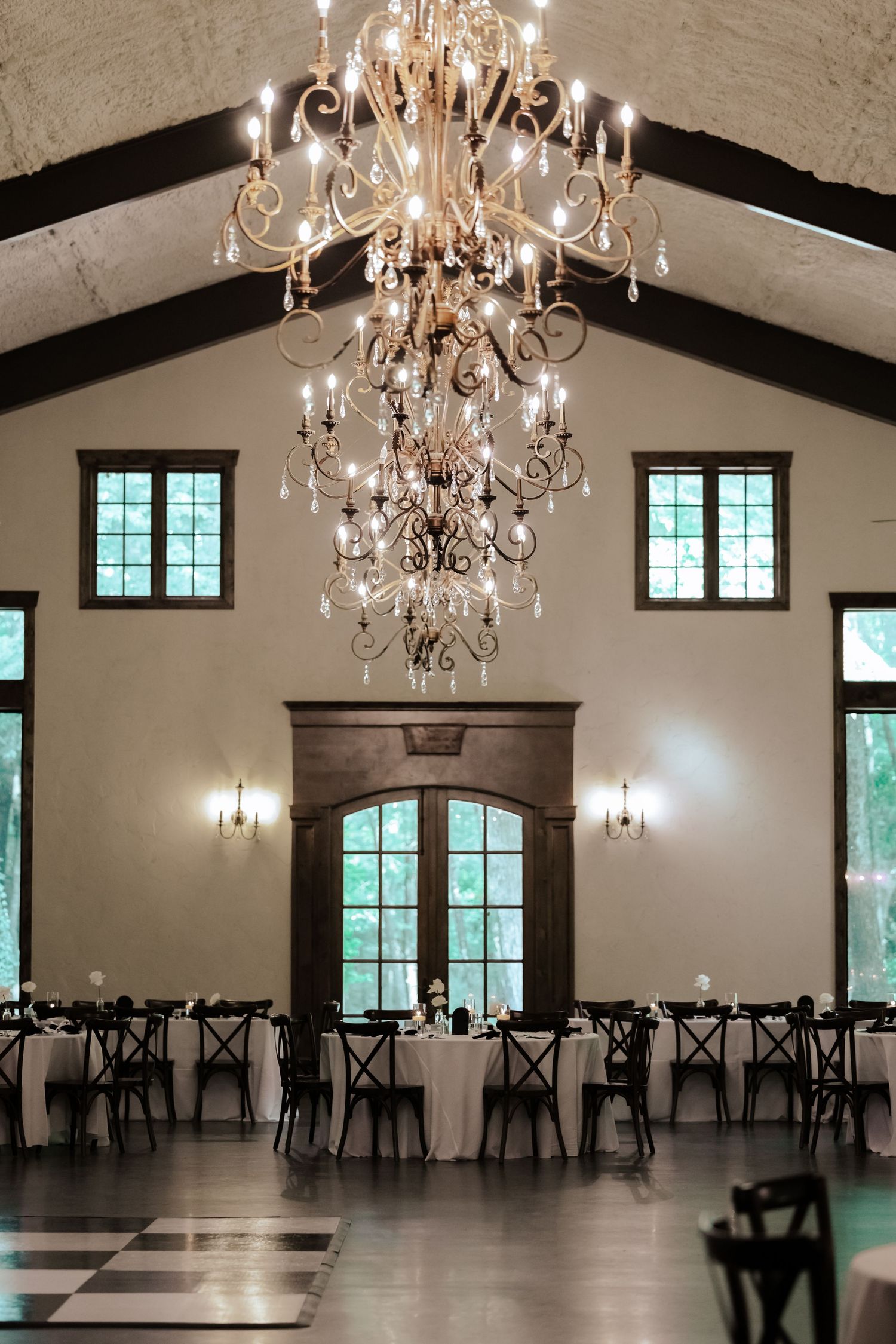 An elegant tuscany italy inspired reception venue with crystal chandelier and high vaulted ceilings.
