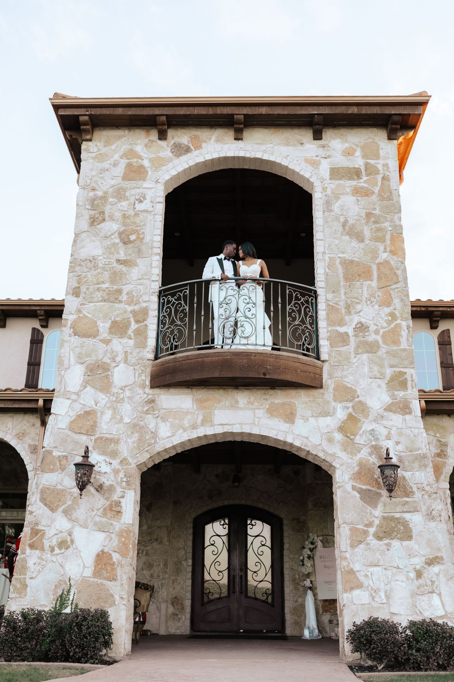 Bride and Groom posing in Stone tuscany inspired venue with arched balconies and italian touch at the Springs Venues in McKinney, TX