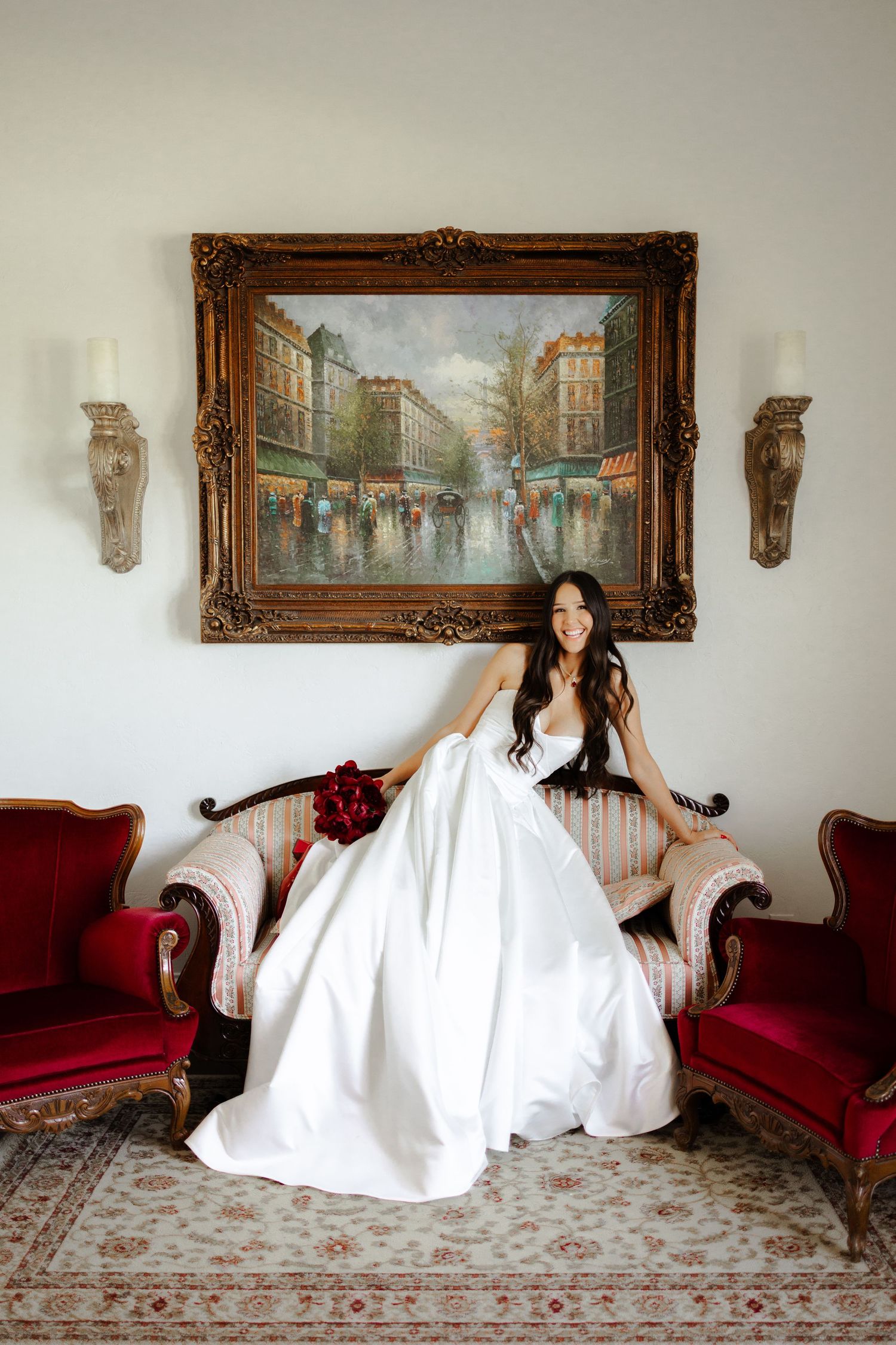 A series of artistic photos showing flowing white fabric movement across an elegant red couch with framed artwork.