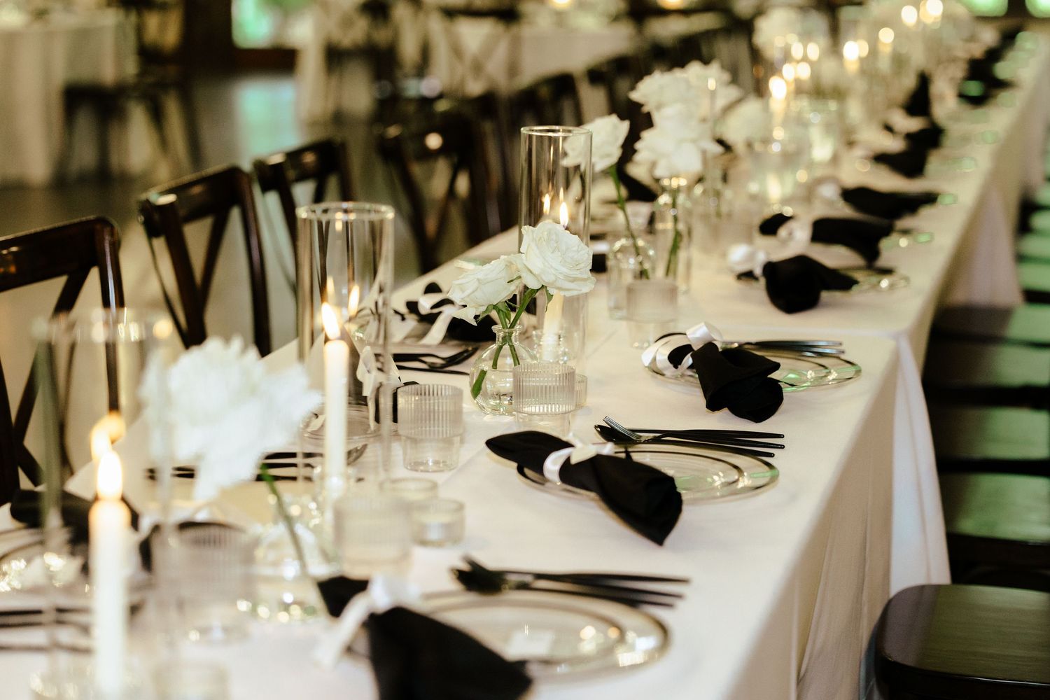 An elegant black and white table setting with formal place settings and bow tie napkin details.